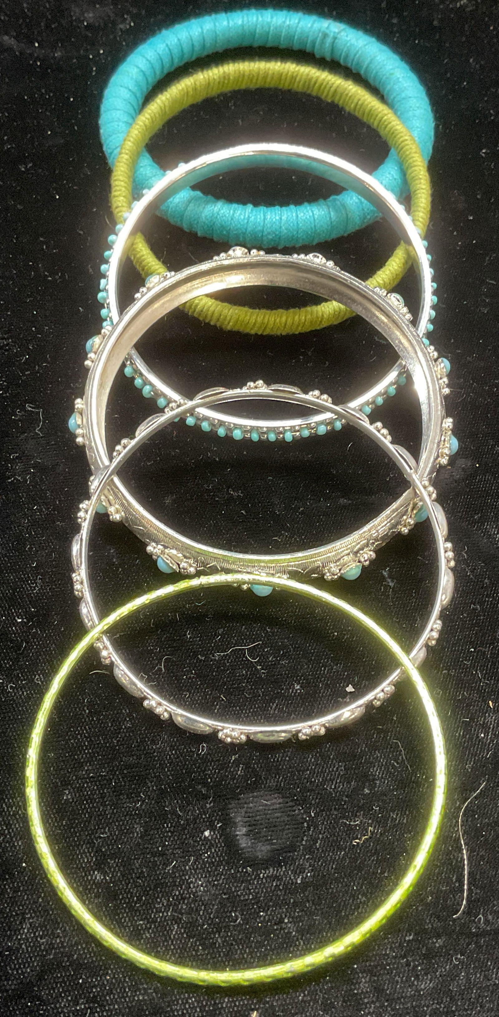 Lot 6 Silver Tone Faux Turquoise Bangles +: Lot of 6 bangle bracelets. 1 silver tone floral, 2 silver tone with faux turquoise cabochons, 1 green metal, 1 blue fabric, and 1 green fabric. Sizes vary slightly, approx 2 5/8 inches wide. Some wear