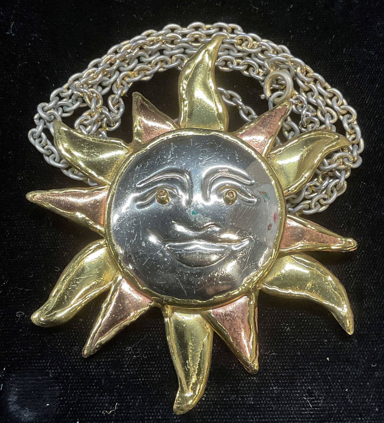 XL Sun Pendant Necklace, 3.75 Inches Wide: Silver, gold, and copper toned sun motif pendant on silver tone chain. Drop length approx 18 inches. Pendant approx 3.75 inches wide. Pin on pendant needs repair. Some wear including scratching observ