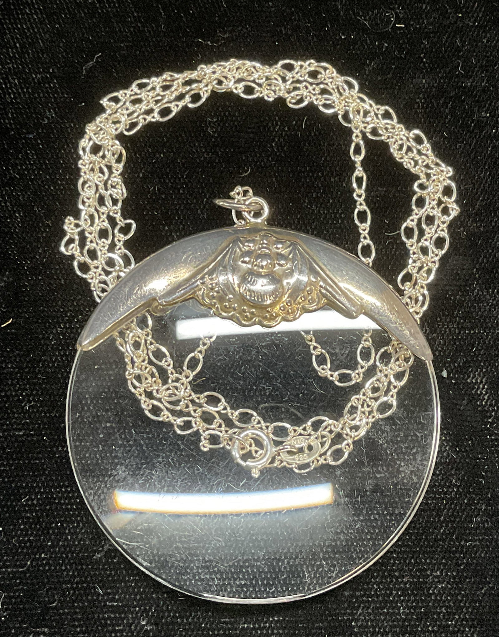 Signed Sterling Silver Magnifying Glass Necklace: Sterling silver magnifying lens pendant on sterling silver chain. Chain signed NC, pendant signed REO. Both marked sterling. Drop length approx 15 inches. Pendant approx 2 inches wide. Lens is plastic
