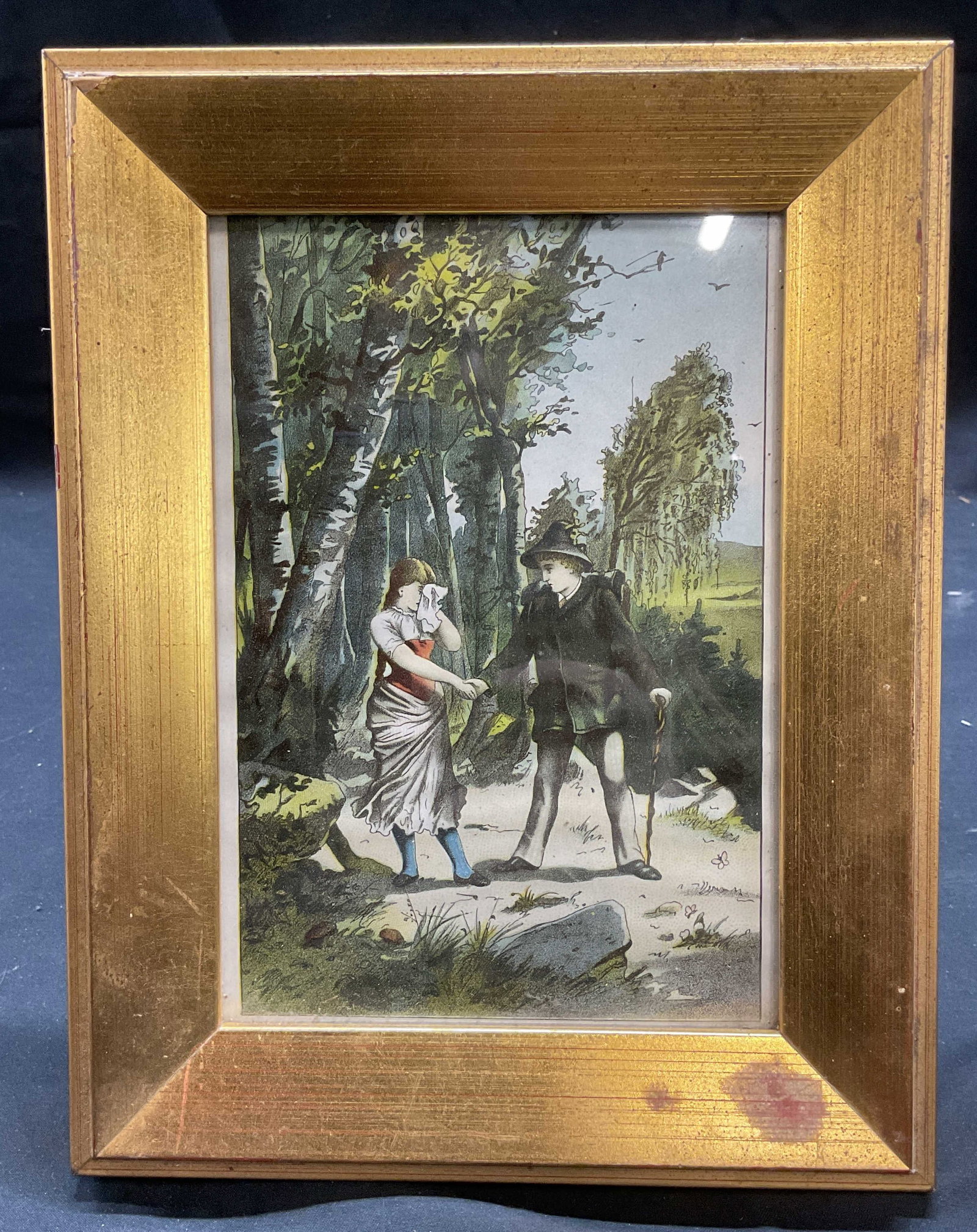 German Folktale Lucky Hans Chromolithograph Print: Framed print. German Folktale scene from Lucky Hans. Woman with handkerchief and man with walking stick in forest. Appears to be a Chromolithograph print. Framed in gilt wood frame. Not examined out o