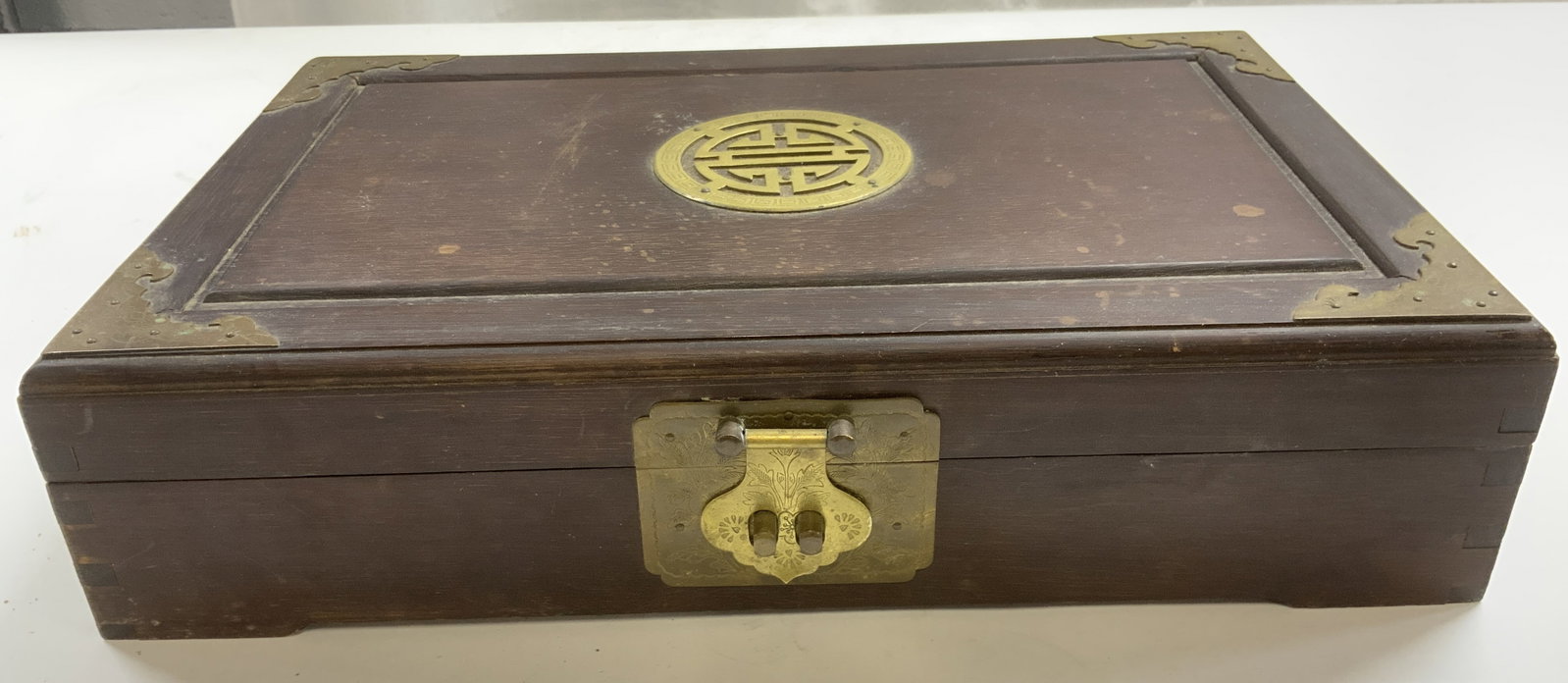 Vintage Asian Wooden Jewelry Box w Lid: Jewelry box is brown toned and wooden. Piece has gilt locking mechanism and medallion ornamentation in center of lid. Interior is green toned & divided into 5 areas. Piece appears to have hand crafted
