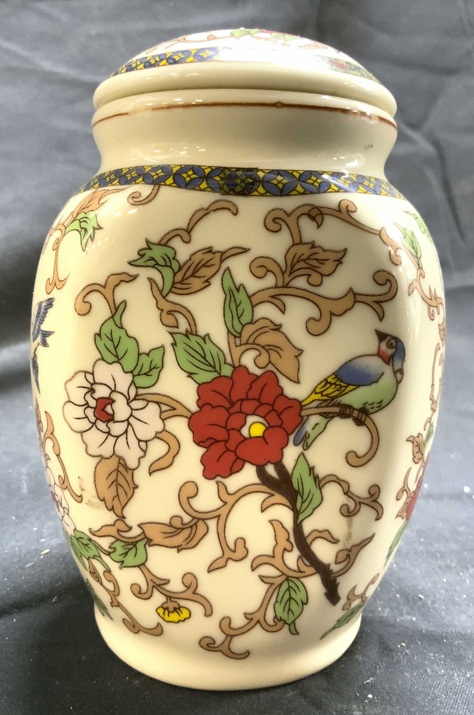 Signed Vintage Asian Porcelain Urn W Lid: Underside is signed with Asian characters. Urn is porcelain. Piece is vintage. Urn includes lid. Piece has intricate multi toned floral motif, scroll and bird detail. Urn measures approximately 4.75 i