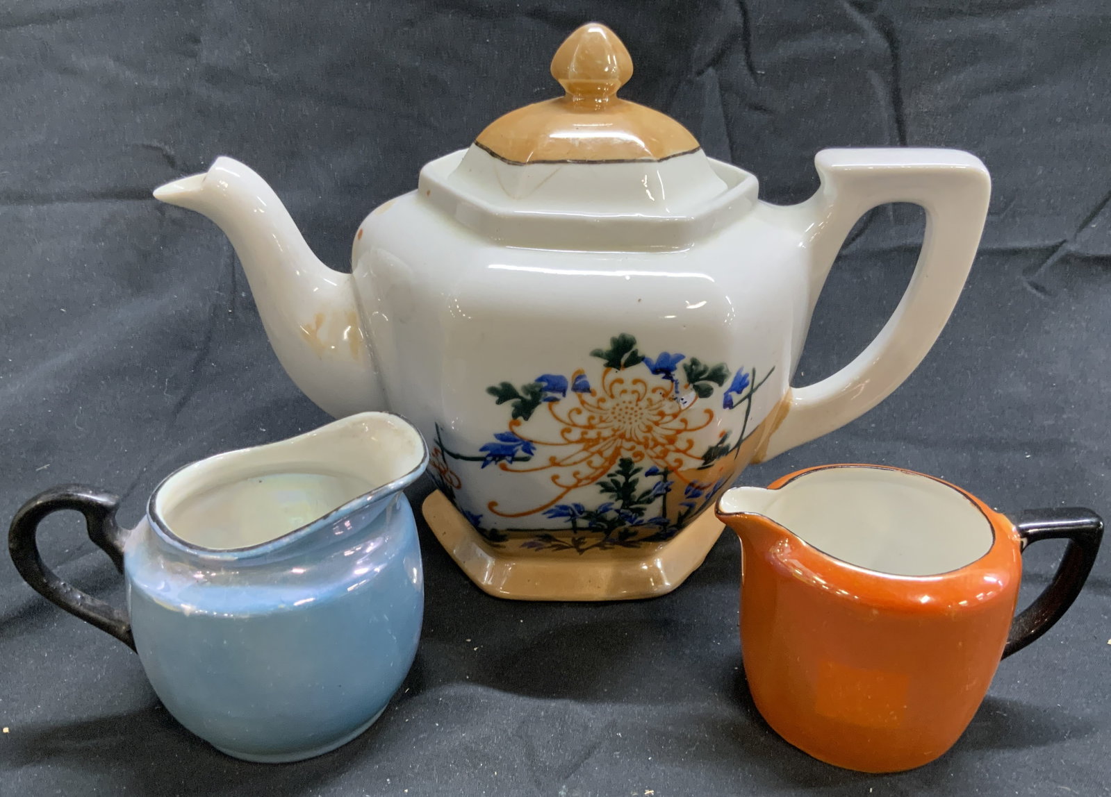 Lot 3 Vntg Porcelain Teapot & Creamers Czech & Jpn: Lot includes 1 teapot with lid, & 2 creamer dishes. Each piece is porcelain. Teapot has hand painted floral and leaf detail. Lot includes 1 orange (underside marked RALT CZECHOSLOVAKIA) & 1 blue cream