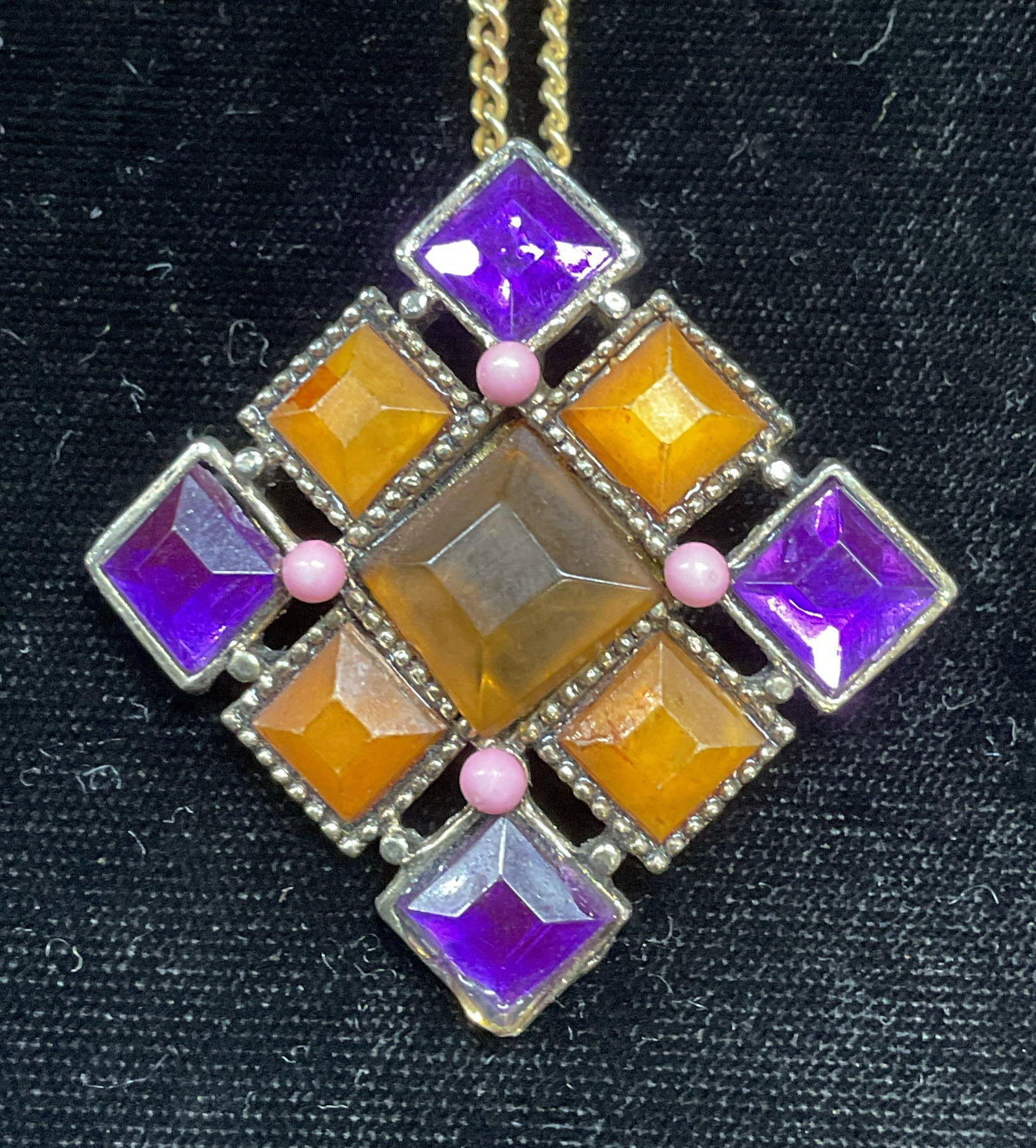 Gold Tone Crystal Pendant Necklace: Gold tone chain necklace d with gold tone pendant. Orange and purple crystal decoration. Pendant measures approx 1.75 x 1.75 inches. Drop length approx 8 inches. Some wear including scratching. Jewelr