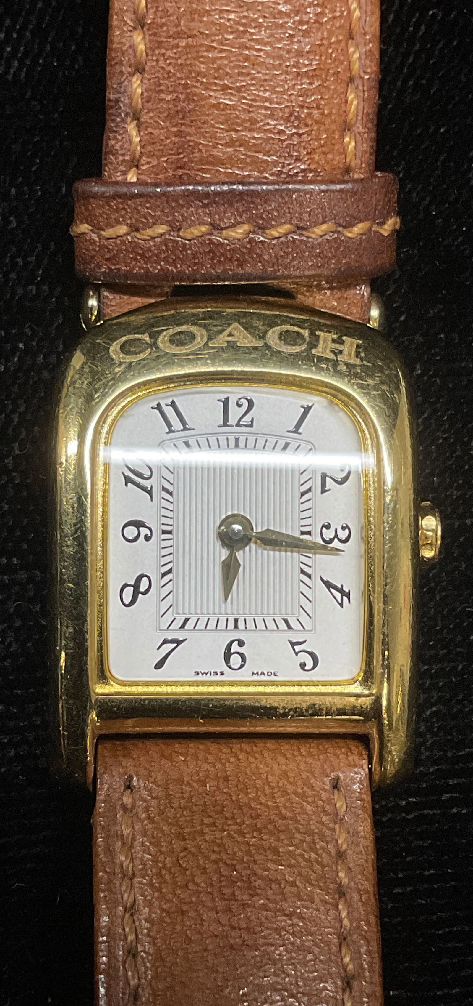 Coach Gold Tone Tan Leather Watch: Coach gold tone watch with tan leather strap. Signed on dial. Measures approx 7.25 inches long. Not tested for function. Some wear including scratching observed. Jewelry, estate jewelry, costume jewel