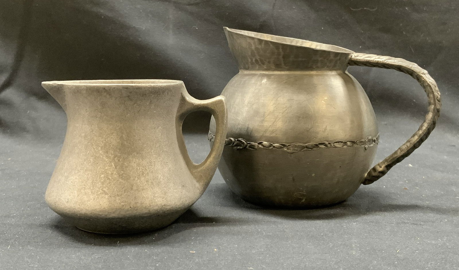 Lot 2 Signed Pewter Creamer, Norway+: Lot of 2 Creamers, one pewter creamer signed on the underside and made in Norway. Other is a metal creamer. Measurements of Pewter creamer: width: 3in, height: 3in Has wear and tear, scratches on surf