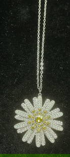 Swarovski Touchstone Crystal Flower Necklace: Touchstone by Swarovski silver tone pendant necklace. Flower motif pendant with yellow and colorless Swarovski crystals. Signed on hang tag. Drop length approx 9.75 inches. Pendant approx 1.25 inches