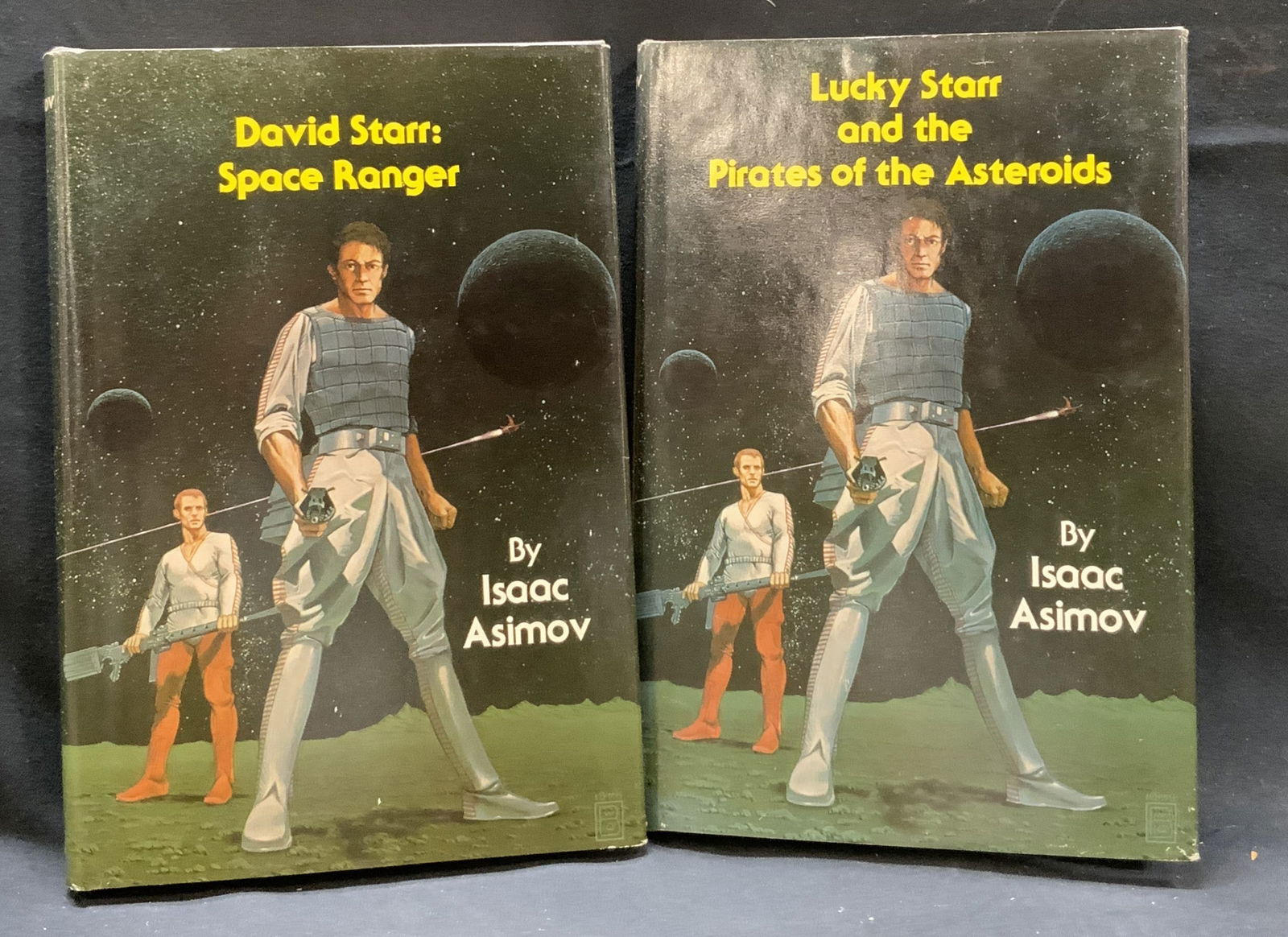 Lot 2 Science Fiction Novels by Isaac Asimov 1952: Lot 2 Science Fiction Novels by Isaac Asimov. David Starr: Space Ranger & Lucky Starr and the Pirates of the Asteroids. 2 hard-cover novels with illustrations on the cover. Depicting an illustration o