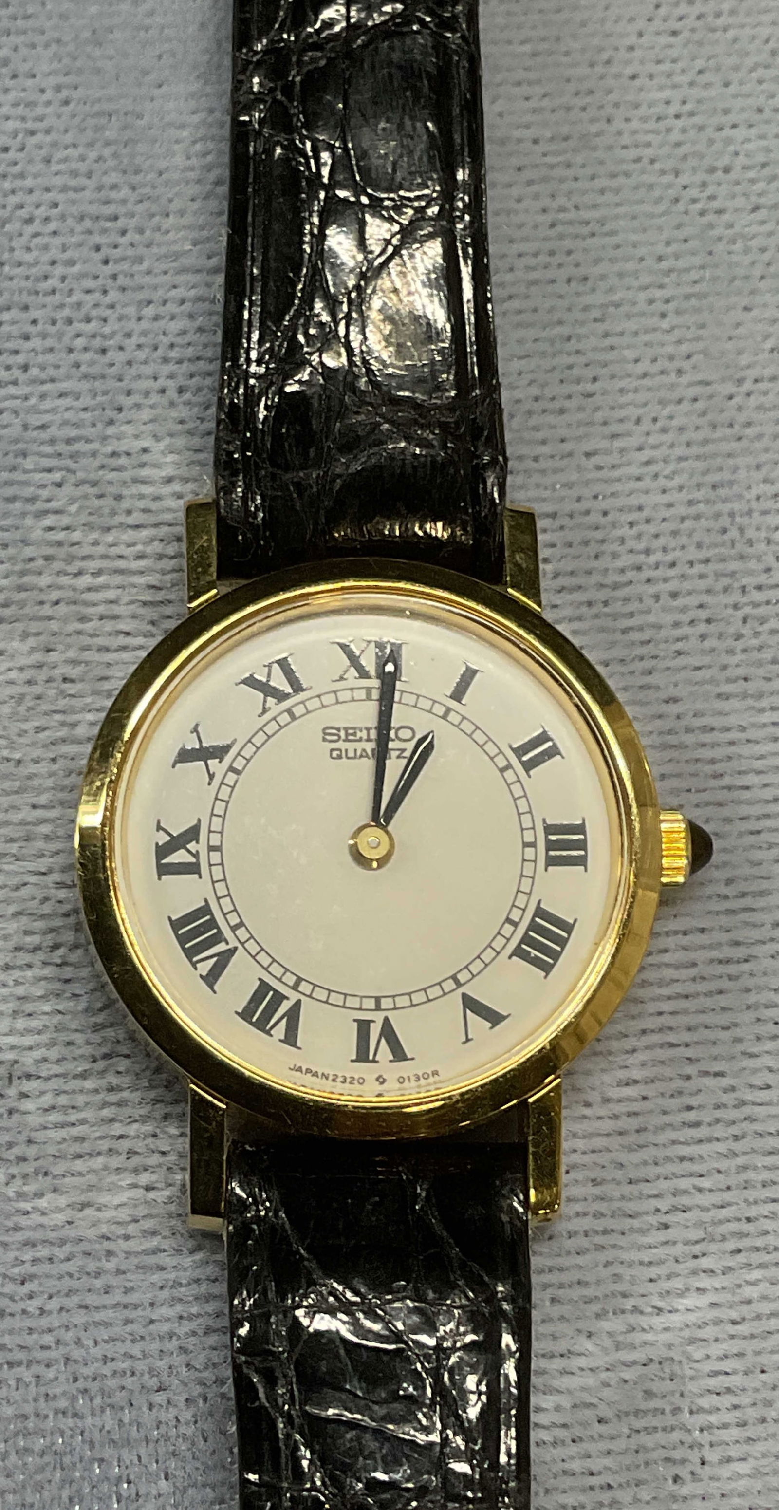 Seiko Gold Tone Black Leather Watch: Seiko gold tone stainless steel case watch with black leather strap. Signed on dial. Measures approx 7.5 inches long. Not tested for function. Some wear including scratching observed. Jewelry, estate