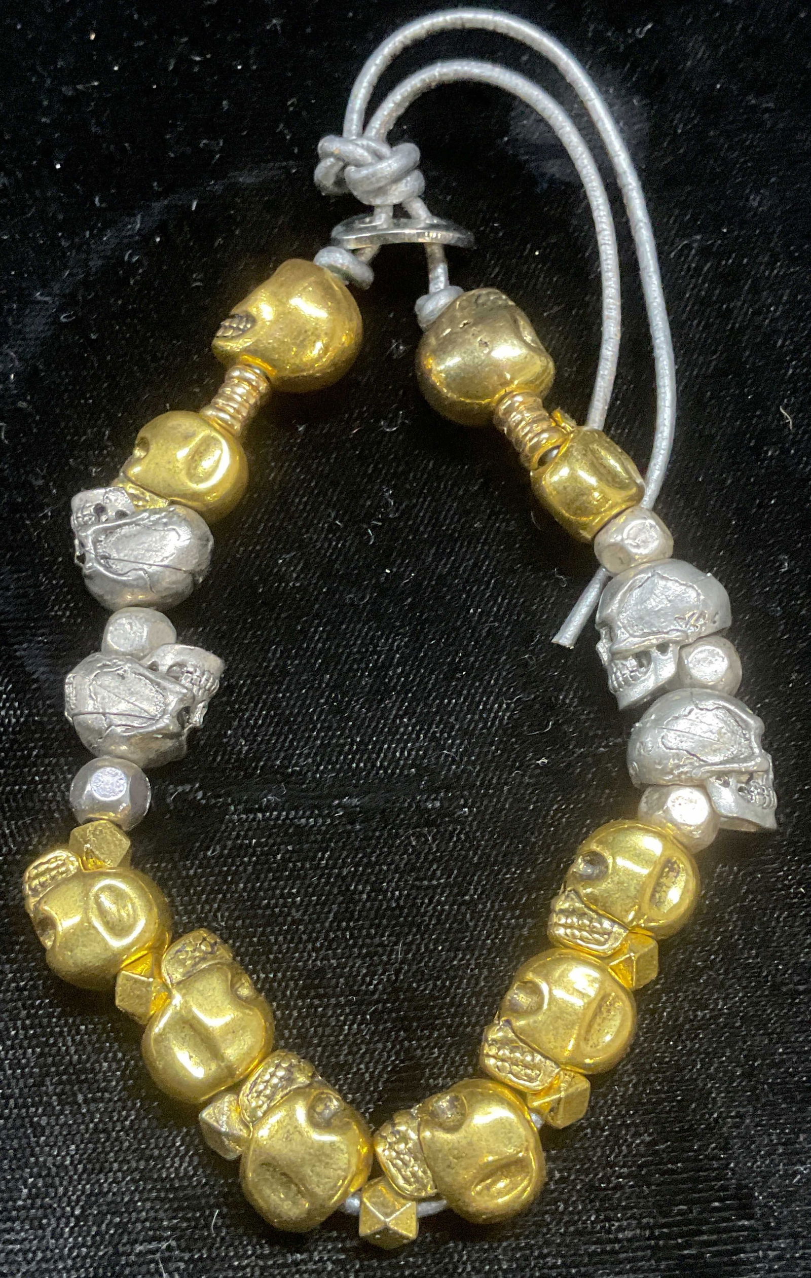 Silver & Gold Tone Skull Beaded Bracelet: Silver and gold tone skull motif beaded bracelet. Pieces have weight. Measures approx 2.25 inches wide, adjustable length. Some wear including scratching observed. Jewelry, estate jewelry, costume jew