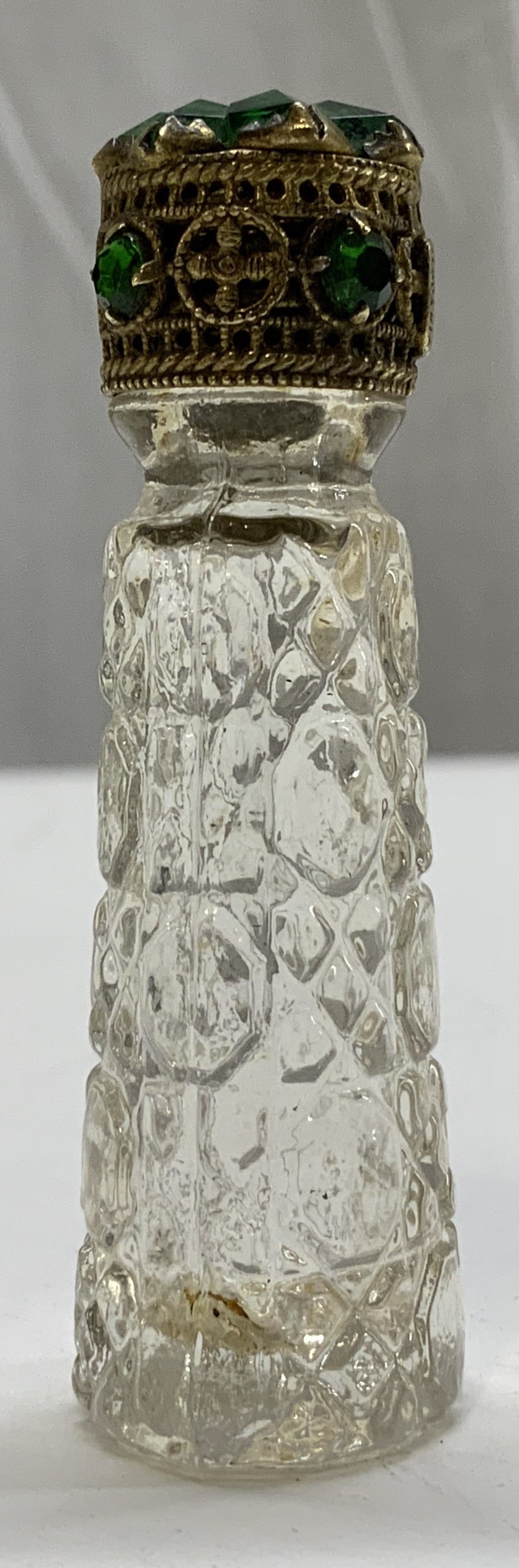 Vintage Irice Jeweled Miniature Perfume Bottle: Vintage Irice Jeweled Miniature Perfume Bottle. Miniature glass perfume bottle with a jeweled cap. Cap has a unique emerald color gemstones. Glass body has a design of ovals & diamonds Labeled on the