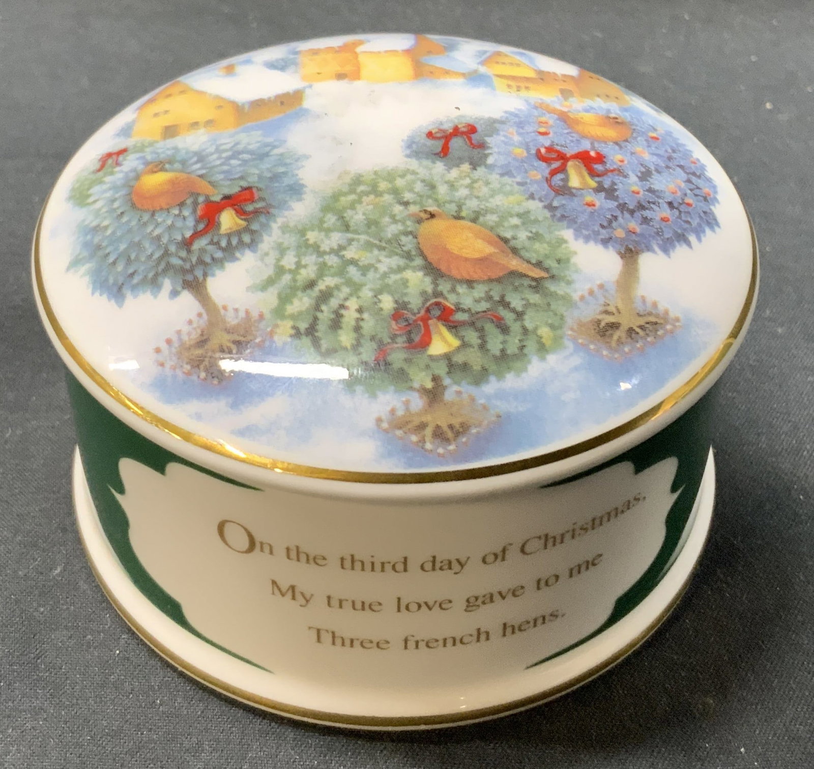 Vintage England WEDGWOOD Christmas Trinket Box: Vintage England WEDGWOOD Christmas Trinket Box. Christmas theme trinket box, has a gold trim lid. The lid has an image of birds standing on Christmas trees. The trinket box has a green base color with