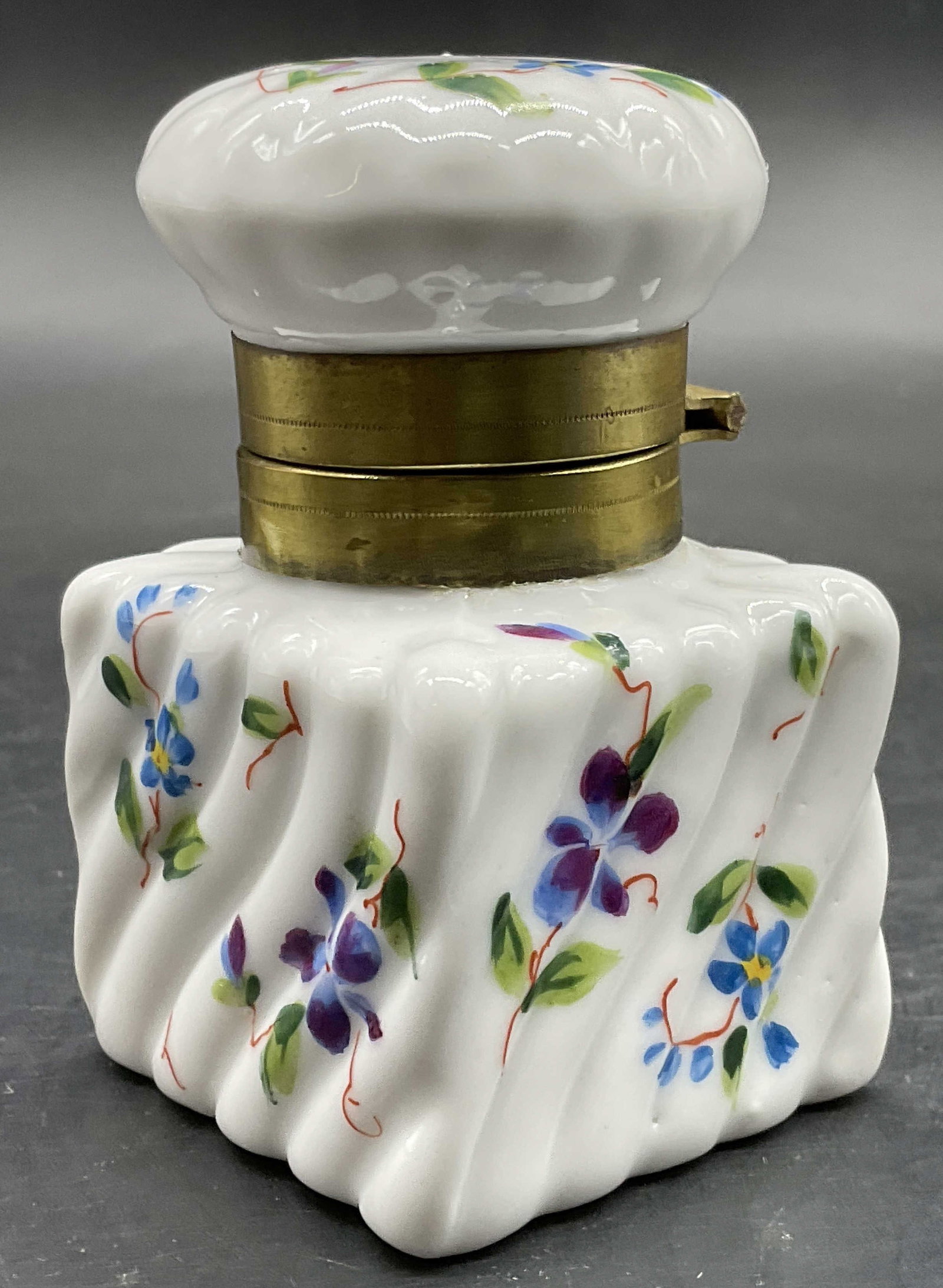 Vintage Hand Painted Floral Ceramic Ink Well: Vintage Hand Painted Floral Ceramic Ink Well. Opens with brass hinge hardware. Measures approx. 3H x 1.75W in. Pitting and discoloration present. Surface wear consistent with age, use, and exposure. h