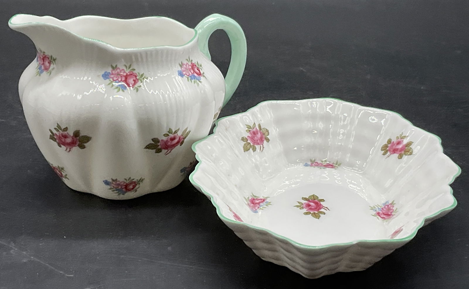 SHELLEY ENG Fine Bone China Creamer & Under Plate: SHELLEY ENGLAND ROSEBUD Fine Bone China Creamer & Under Plate. Ribbed fine bone china accents alongside rosebuds and other florals. The underside of the under plate / trinket dish reads FINE BONE CHIN