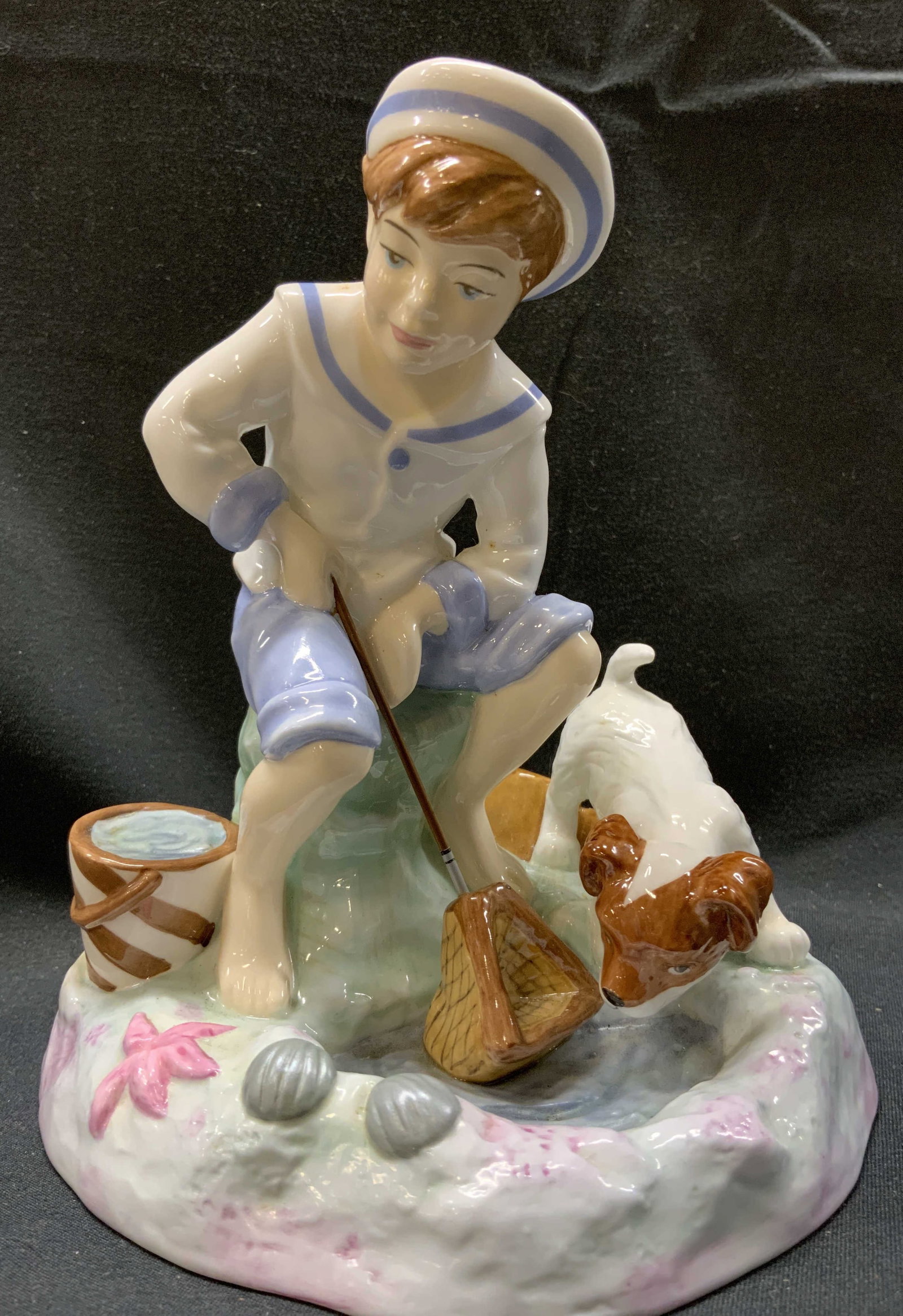 ROYAL DOULTON England Caught One Boy Fishing Fig: ROYAL DOULTON England Caught One Boy Fishing Fig. Figurine depicting a young boy wearing a long-sleeved shirt with blue trim collars and cuffs. Including a white sailor hat with a blue band. He is hol