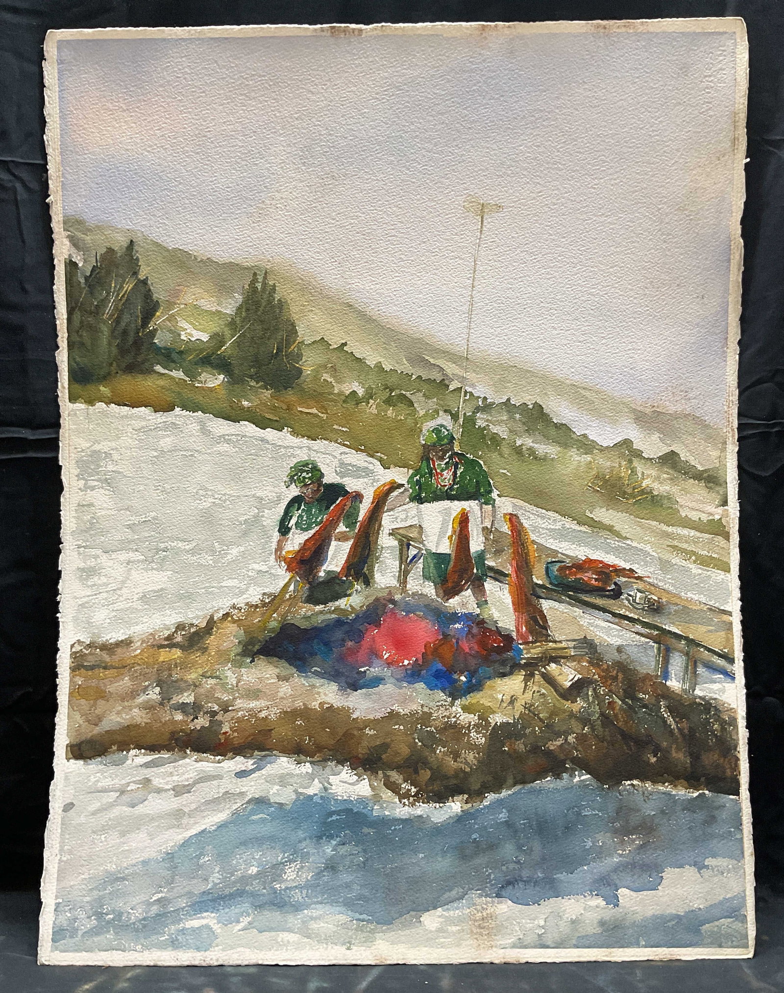 Winter Scene Figural Watercolor Painting: Watercolor painting on paper. Winter scene with figures, fire, and table. Paper measures approx 22.5 x 30 inches. Some wear including rubbing observed. Watercolor painting, works on paper. Winter scen