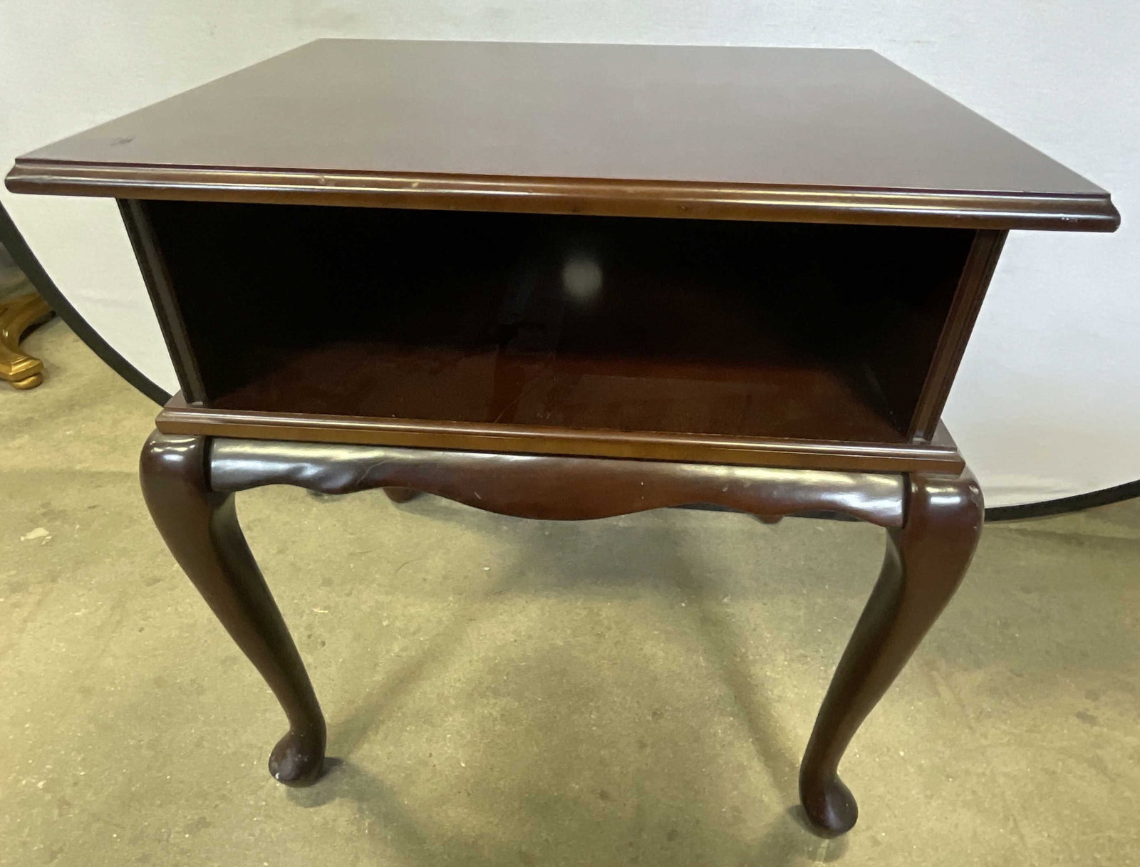 THE BOMBAY COMPANY Brown Wooden Side Table: THE BOMBAY COMPANY Brown Wooden Side Table. Four legs to the piece. Open center for storage. Tag to underside reads THE BOMBAY COMPANY. Measures approx. 26H x 23.5W x 19D in. Loose pieces, separation,