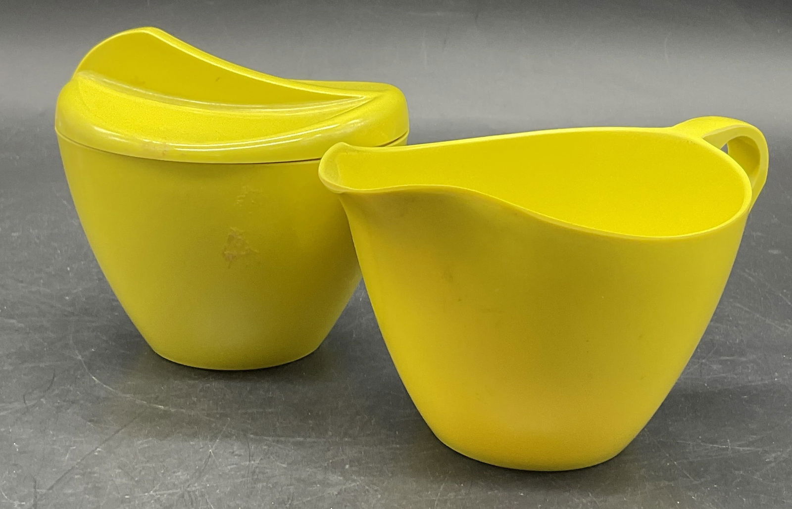 Set Vintage Yellow Melamine Creamer & Sugar Bowl: Set Vintage Yellow Melamine Creamer & Sugar Bowl. The creamer measures approx. 3H x 5.5W in. Measured at widest point. Underside of creamer is numbered 311 4. Surface wear consistent with age, use, an