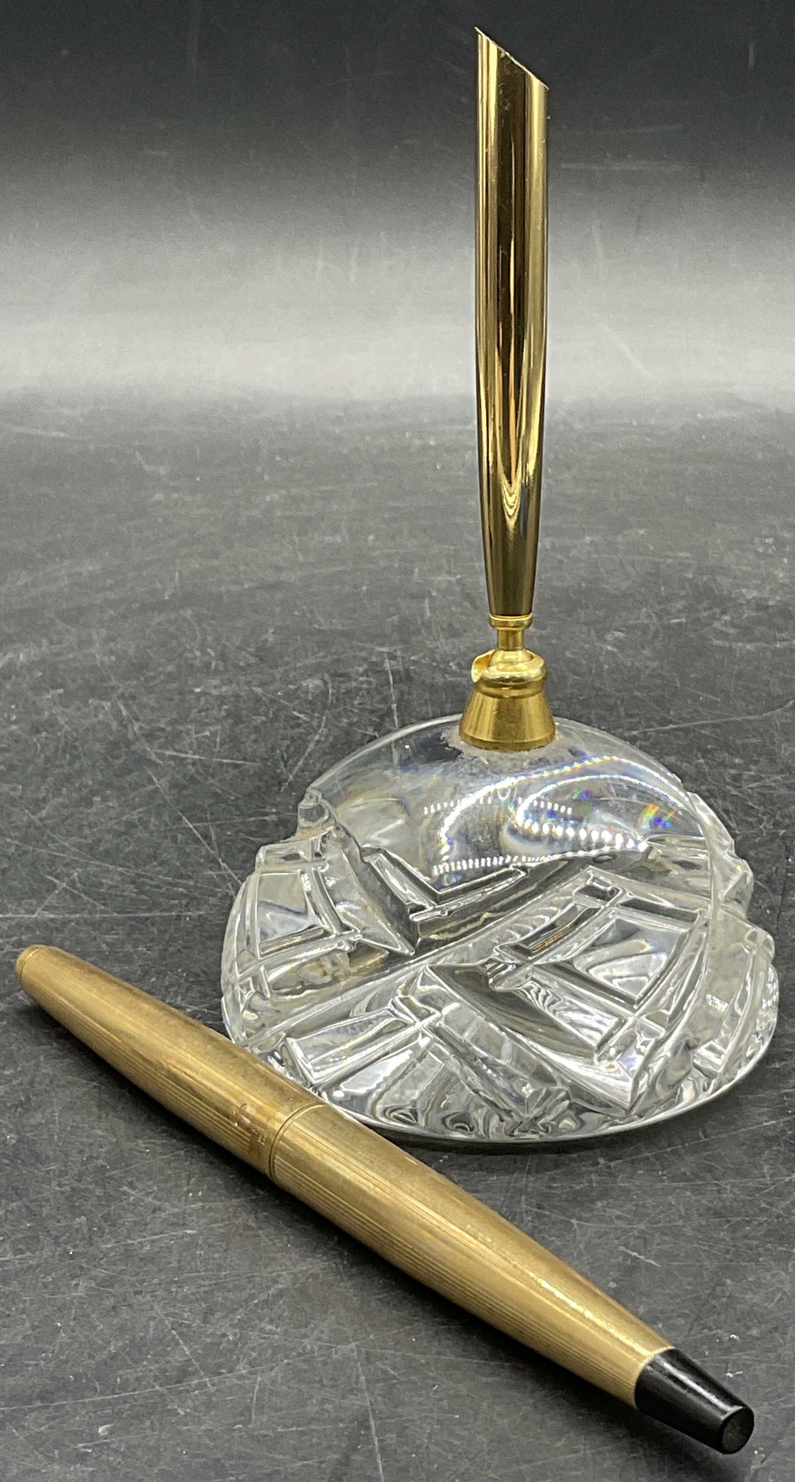Cut Crystal Desktop Pen Holder & Parker French Pen: Cut Crystal Desktop Pen Holder & Parker French Pen. Colorless crystal pen holder / paperweight has a gold tone metal adjustable embellishment for holding pens. Measures approx. 5.25H x 3W in. The pen 