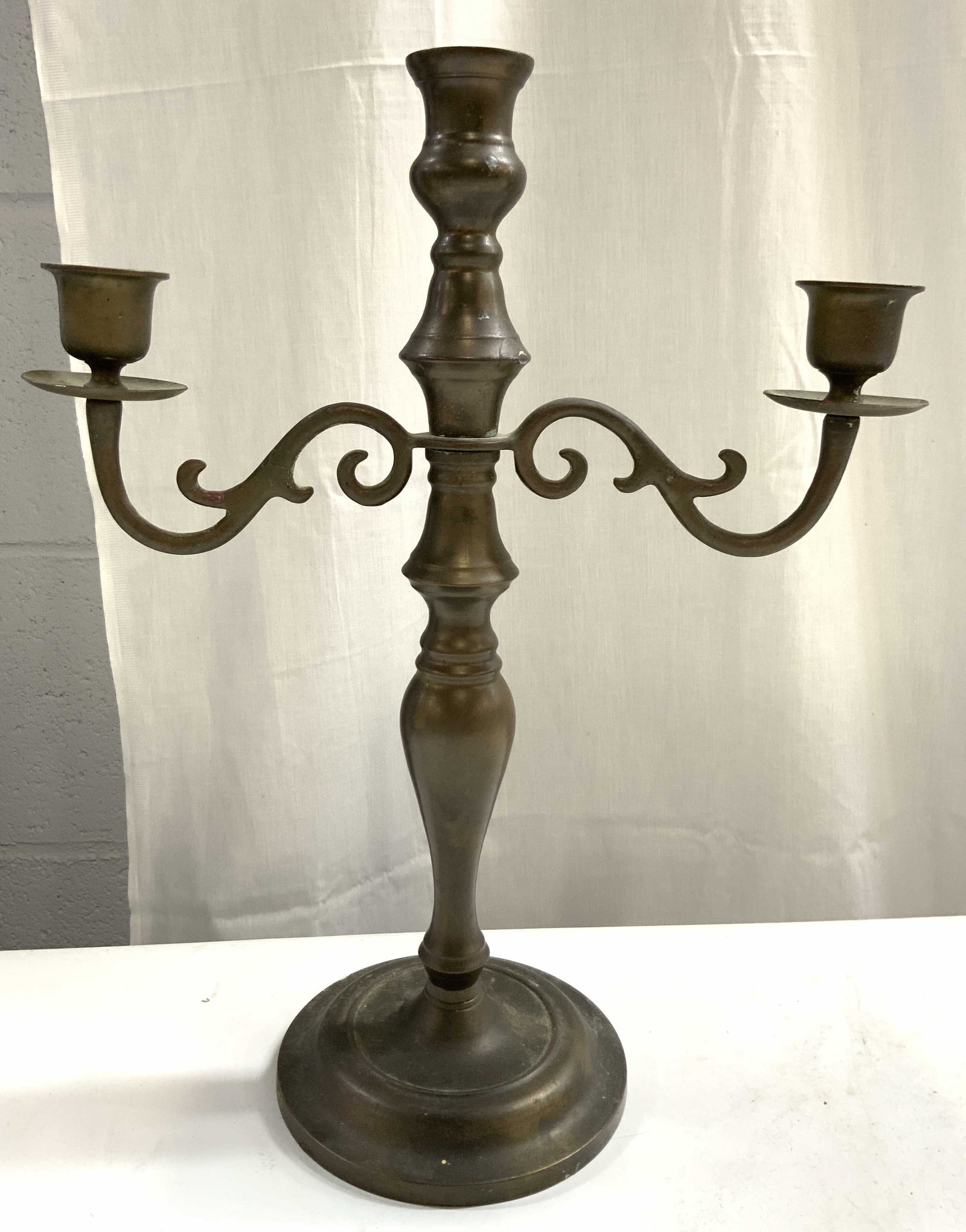 Vintage 3 Arm Gilt Metal Candelabra: Candelabra is vintage. Piece has 3 arms. Candelabra is gilt metal. Piece has circular form base. Arms have S curl detail. Piece measures approximately 14 inches tall 11 inches wide 5 inches deep. Cand