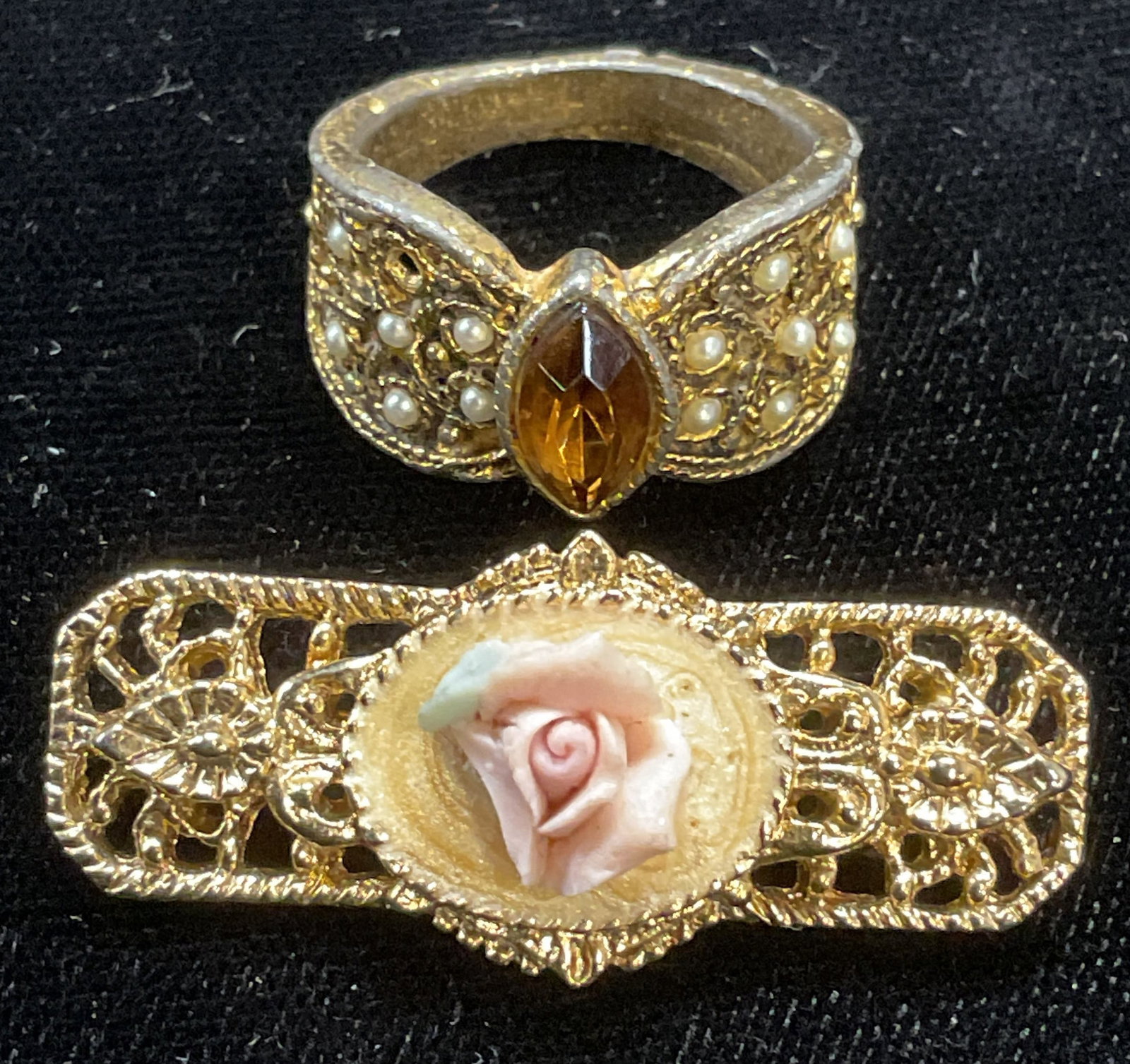 Lot 2 Gold Tone Floral Brooch & Crystal Ring: Gold tone filigree brooch with floral accent and gold tone filigree ring with faux Pearl and amber toned crystal. Ring size 7.25. Interior ring inscribed EIGHT. Brooch approx 1 3/8 inches wide. Some w