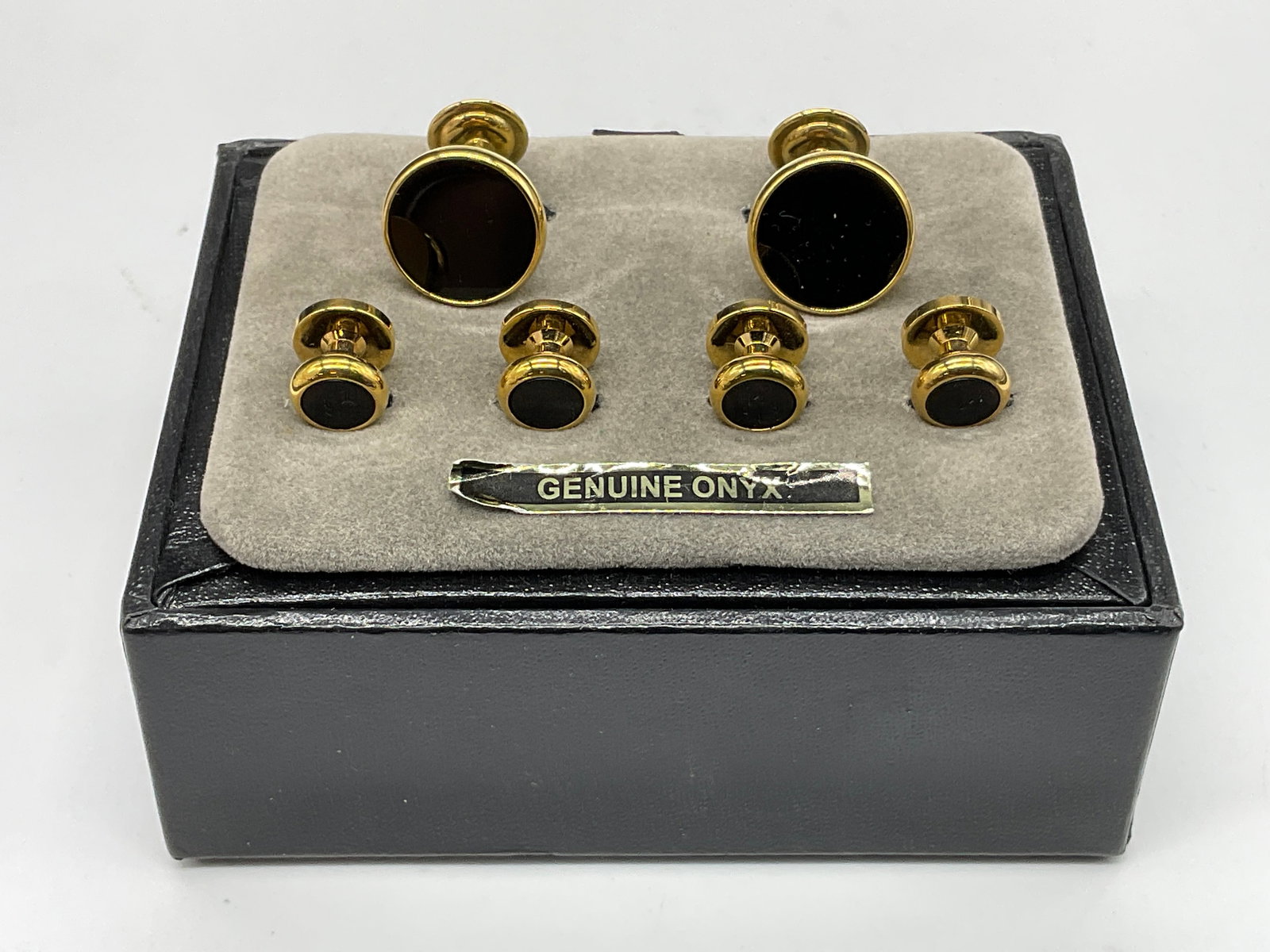 GENUINE ONYX Black & Gold Tone Metal Cuff Links: GENUINE ONYX Black & Gold Tone Metal Cuff Links and Tux Shirt Studs. Sticker reads GENUINE ONYX. The pieces come with their original packaging. Larger cuff links measure approx. 1L x .5W in. Surface w
