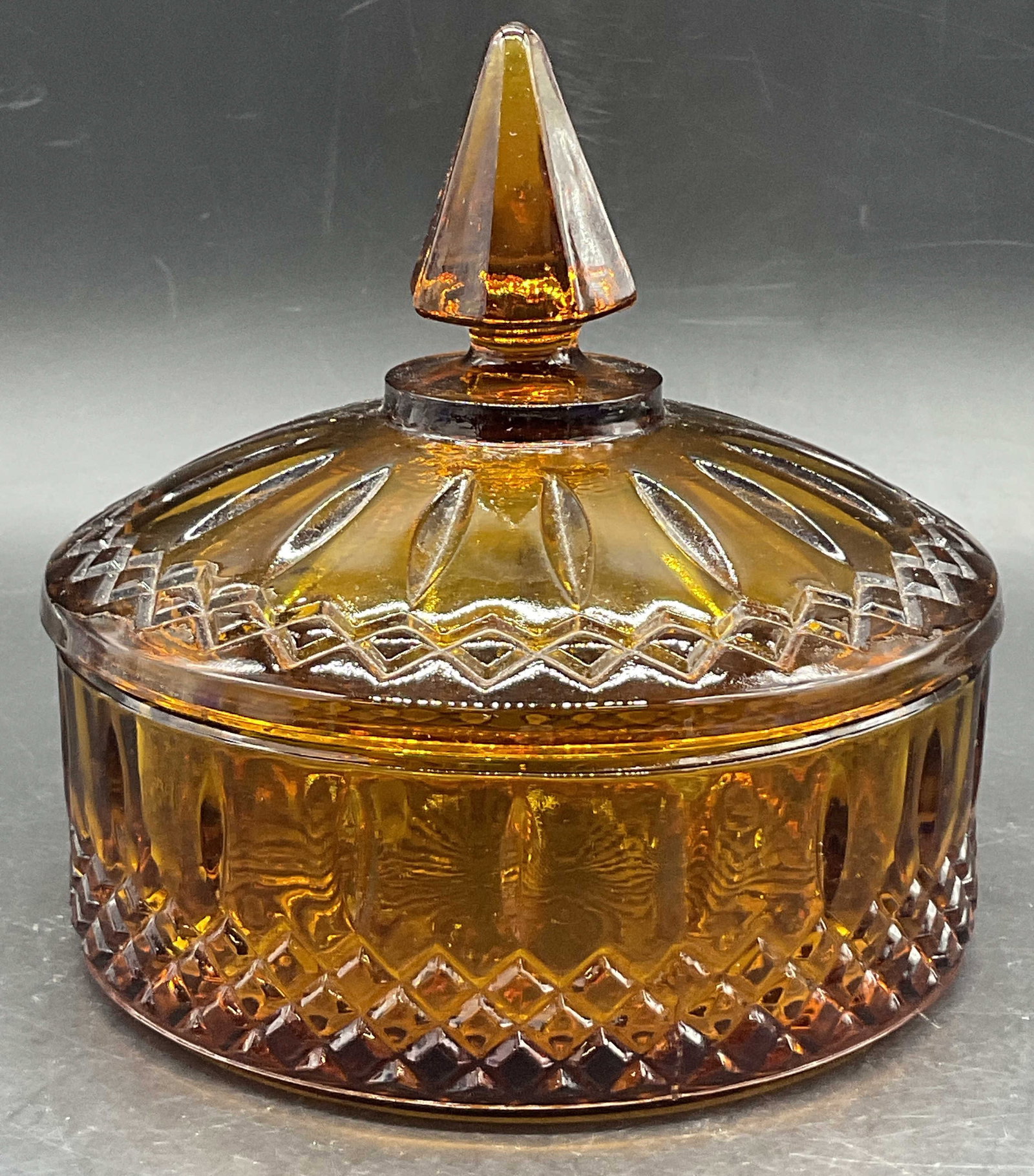 Vintage Cut Amber Glass Trinket Dish, Lidded: Vintage Cut Amber Glass Trinket Dish. Diamond cut pattern and finial to the lid. Measures approx. 6H x 6W in. Seam present. Chipping and surface wear present. home decor, home accents, homewares, hous