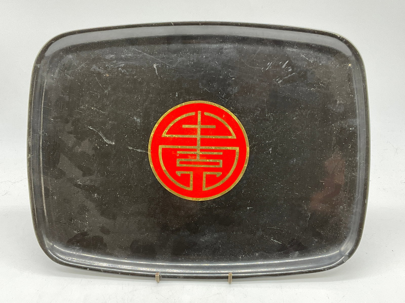 COUROC CALIFORNIA Inlaid Asian Character Tray: COUROC CALIFORNIA Inlaid Asian Character Motif Tray. Black tray with an inlaid bright red Asian character to the center. Measures approx. 9.5L x 12.75W in. Underside possesses a COUROC CALIFORNIA stic