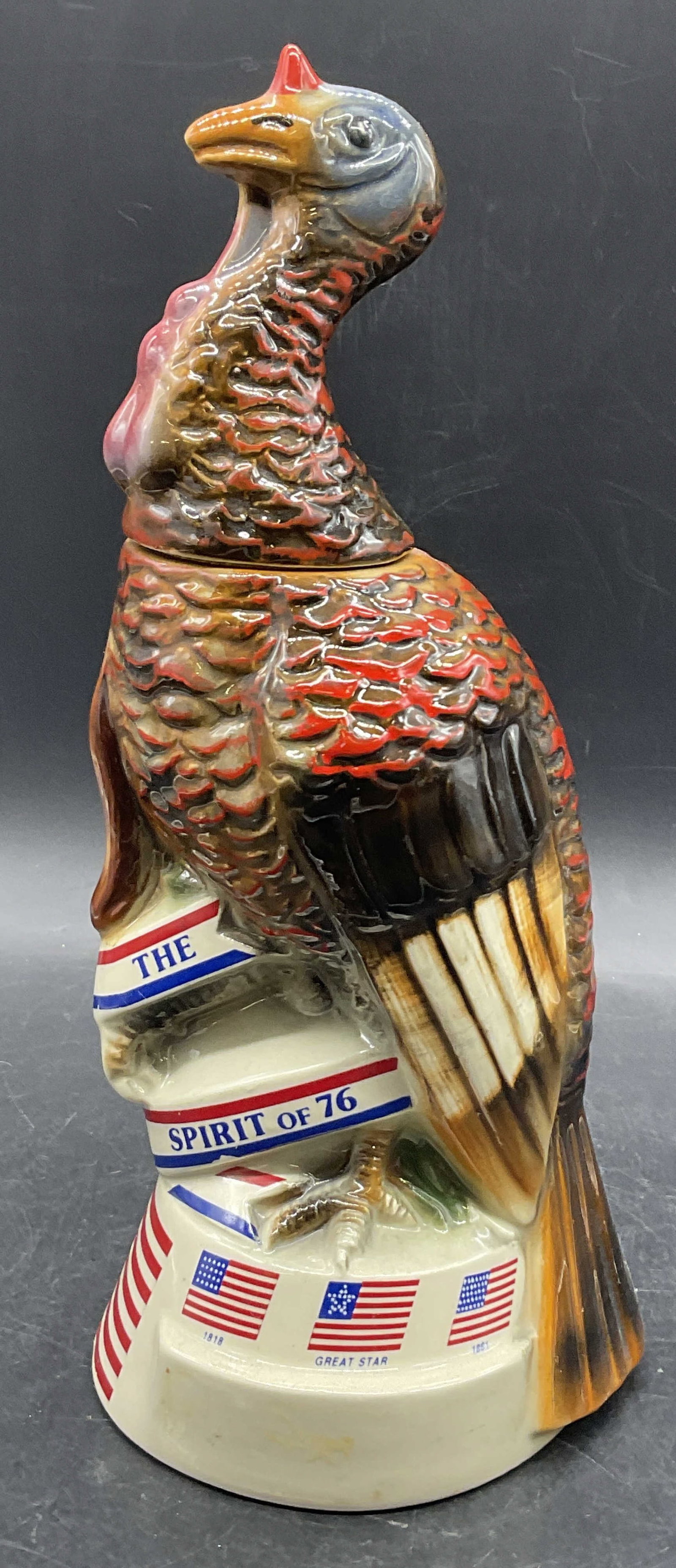 Vntg Austin Nichols Wild Turkey Ceramic Decanter: Vintage Austin Nichols Wild Turkey ceramic decanter. The Spirit of 76 limited edition ceramic No. 5. Measures approx. 12H x 4.5W in. Residue, discoloration, and surface wear present. Writing to piece.
