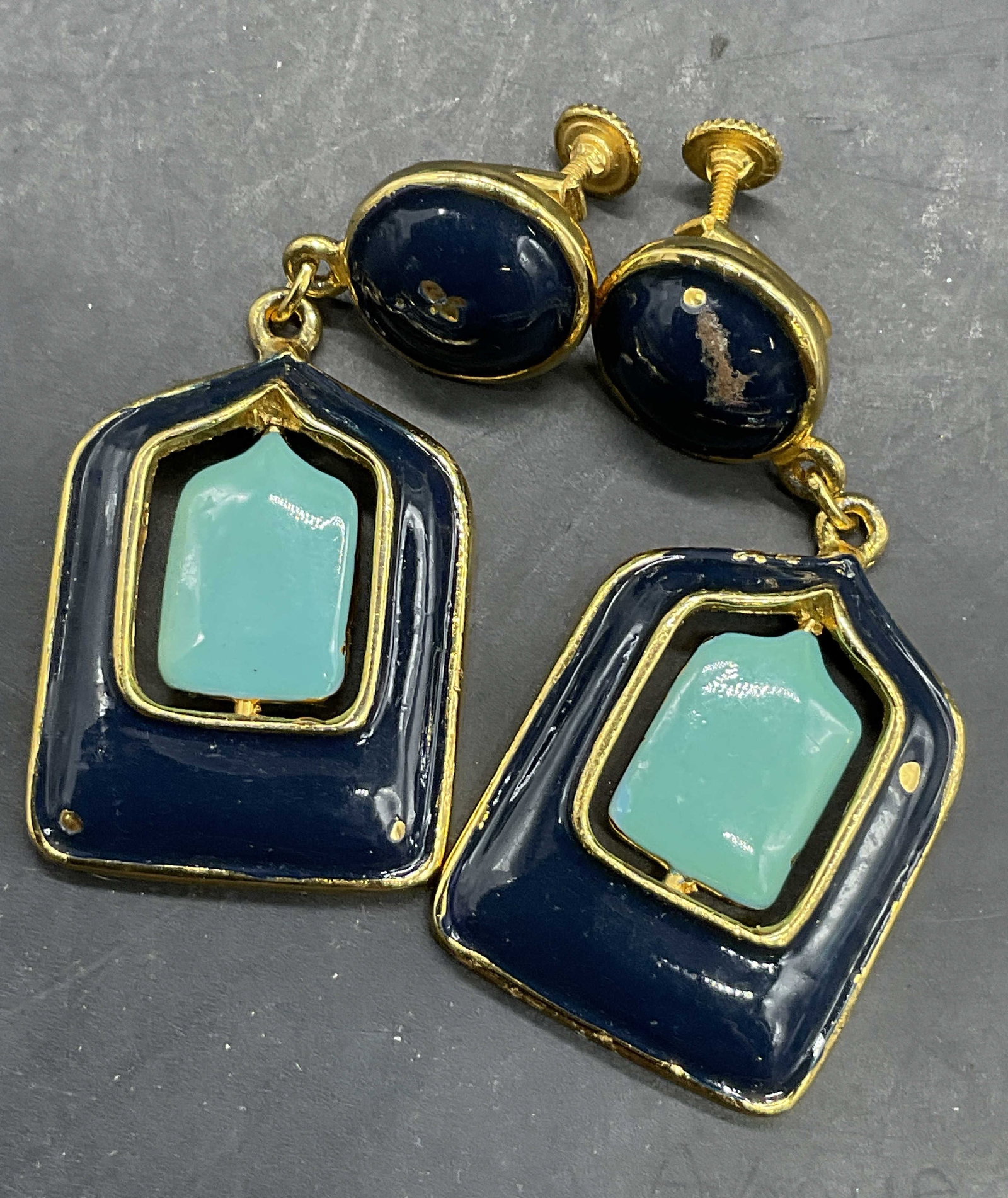 PIERRE CARDIN Vintage Enameled Clip On Earrings: PIERRE CARDIN Vintage Enameled Clip On Screw Back Earrings. Gold tone metal with green and blue enamelwork to the obverse. Center can be reversed. Earrings measure approx. 2L x 1W in. Losses to finish
