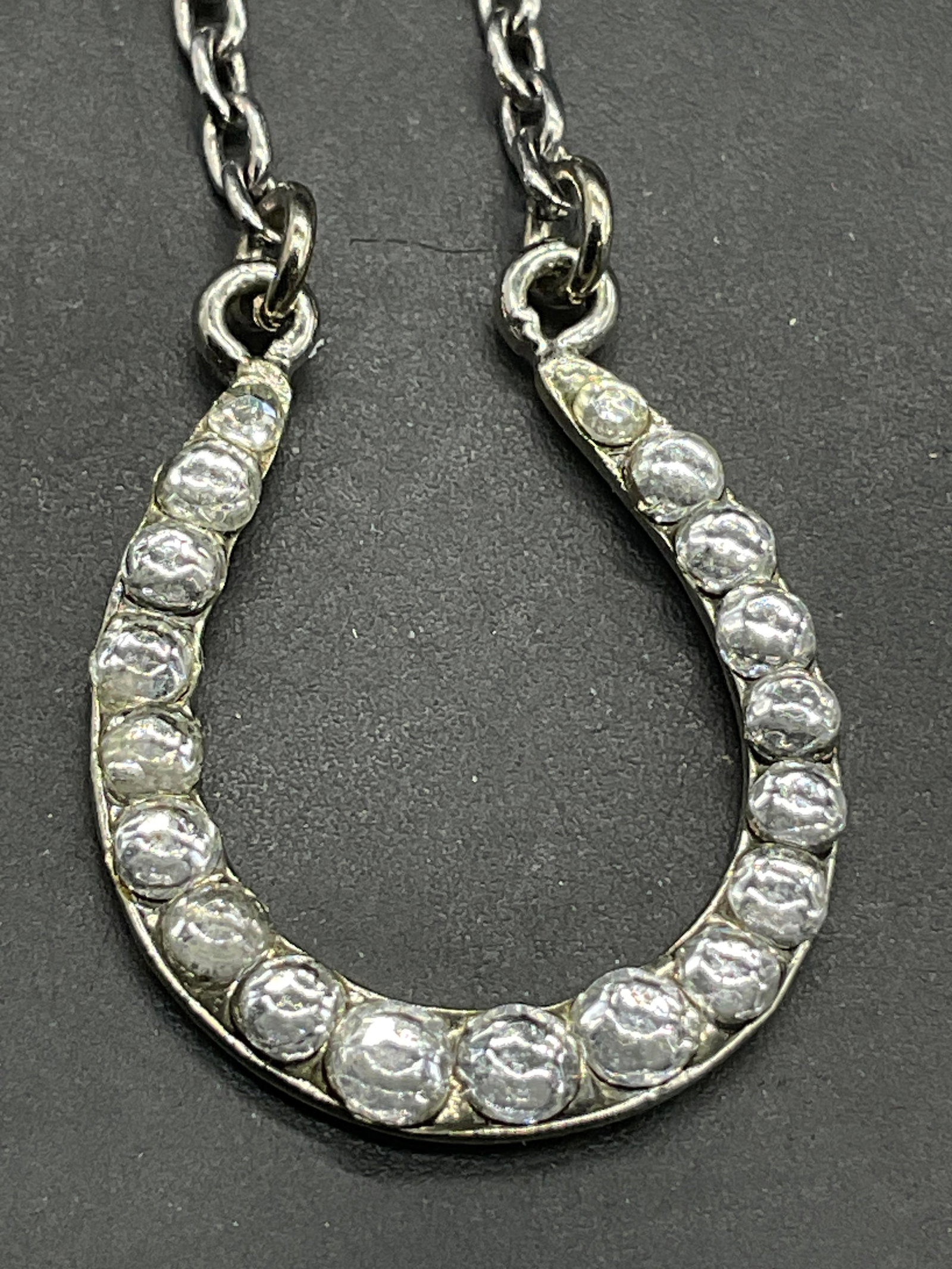 Bejeweled Horseshoe Pendant Choker Necklace: Silver tone metal chain necklace featuring a bejeweled horseshoe pendant. Secures with lobster claw clasp closure. Necklace length measured end to end approx. 15 inches. Surface wear consistent with a