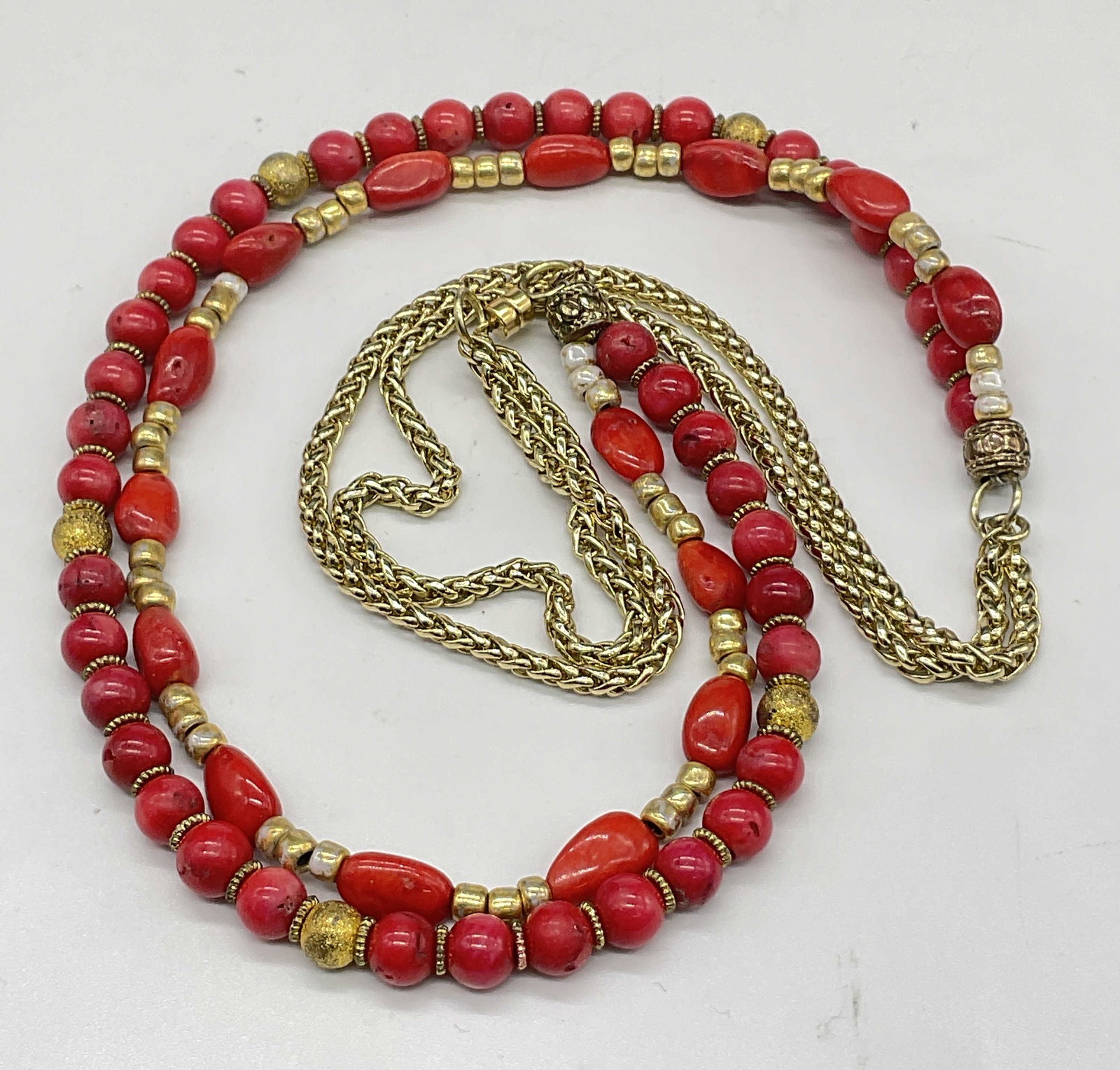 Red Stone Bead Magnetic Clasp Necklace: Double Strand Red Stone Bead Magnetic Clasp Necklace. Comprised of gold tone metal chain, gold tone beads, white beads, and natural red stone organic form beads. Some beads are round and some have mor