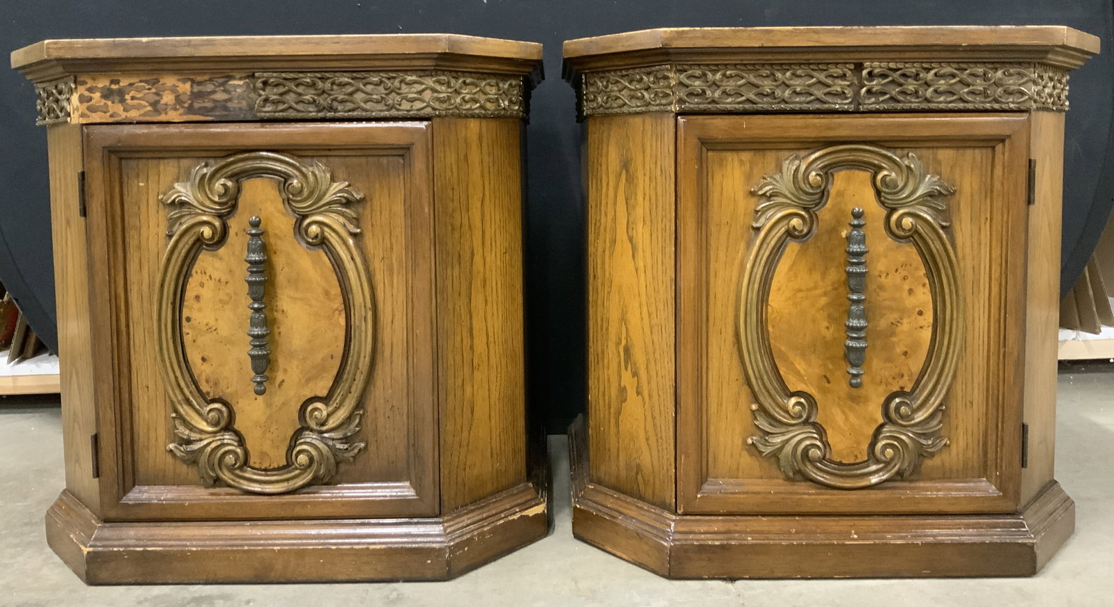 Pair Vintage Wood Veneer Side Tables W Cabinets: Lot includes 2 side tables. Each are brown toned wood veneer. Tables each have gilt metal cabinet handles & carved scroll detail. Canines side tables each measure approximately 24 inches tall 25 inche