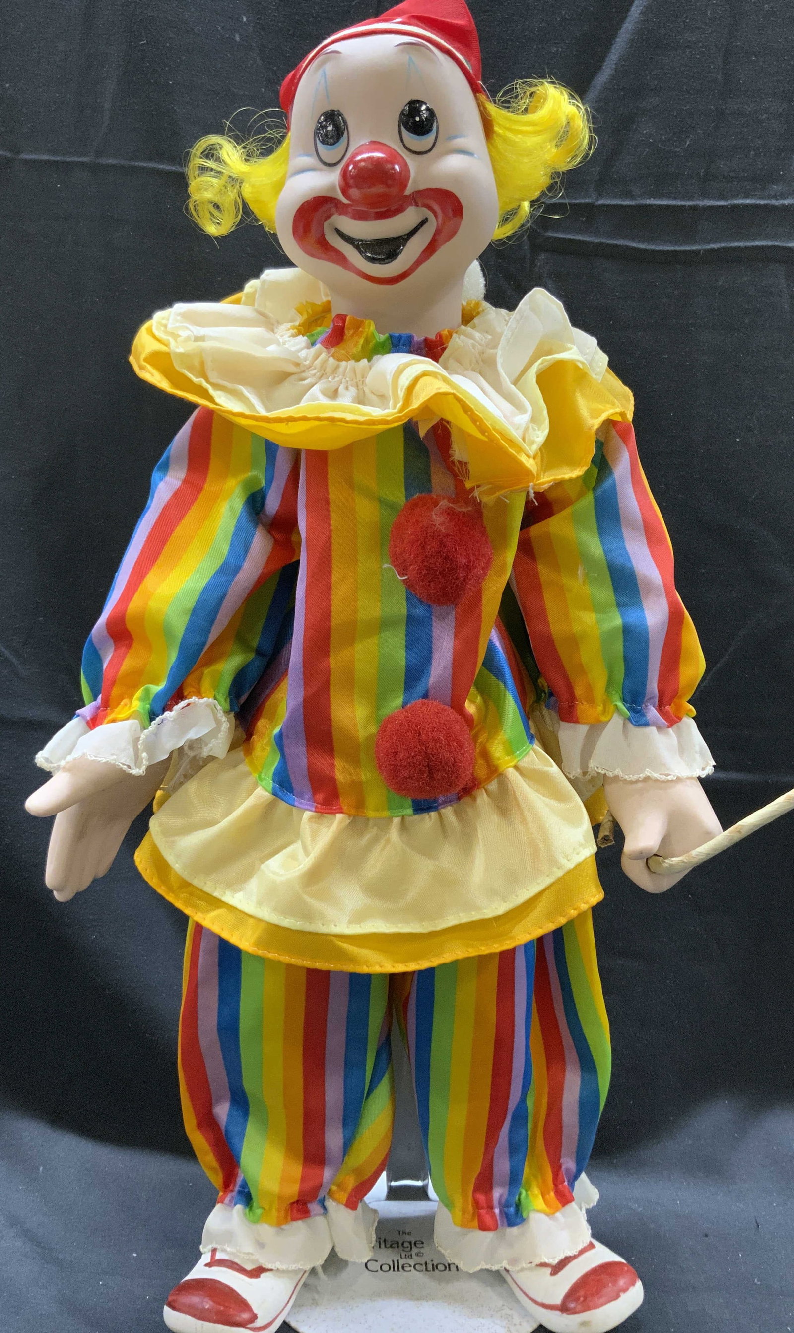 The Heritage Mint Collection Porcelain Clown Doll: The Heritage Mint Collection Porcelain Clown Doll Porcelain clown doll, clown is wearing a colorful striped outfit with a ruffled collar & red pom pons on his top. Including a red hat. Clown has a met