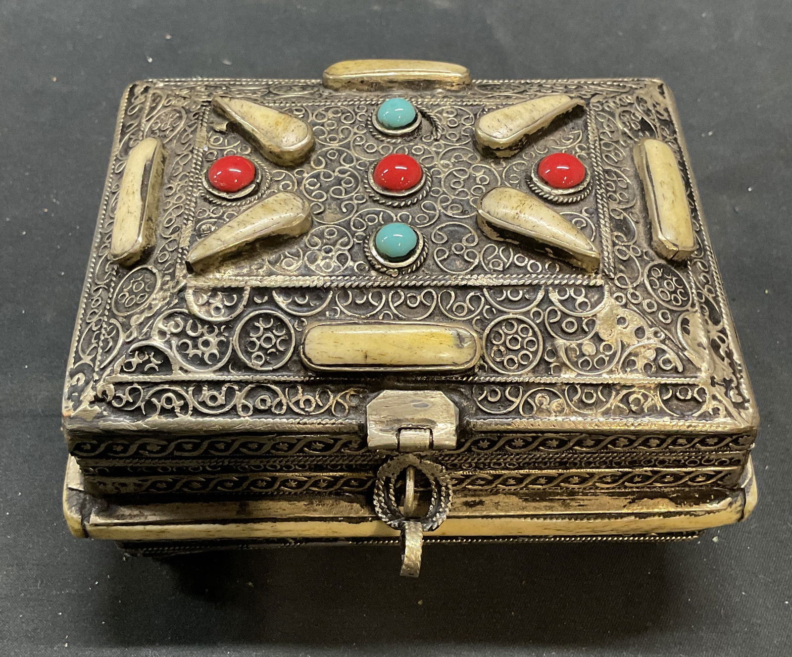 Vintage Asian Silver Tone Semiprecious Jewelry Box: Vintage Asian jewelry box. Silver tone metal with ornate filigree metalwork and inlaid bone and semiprecious stones. Lined interior. Measures approx 5 x 4 x 2.75 inches. Wear including scratching and
