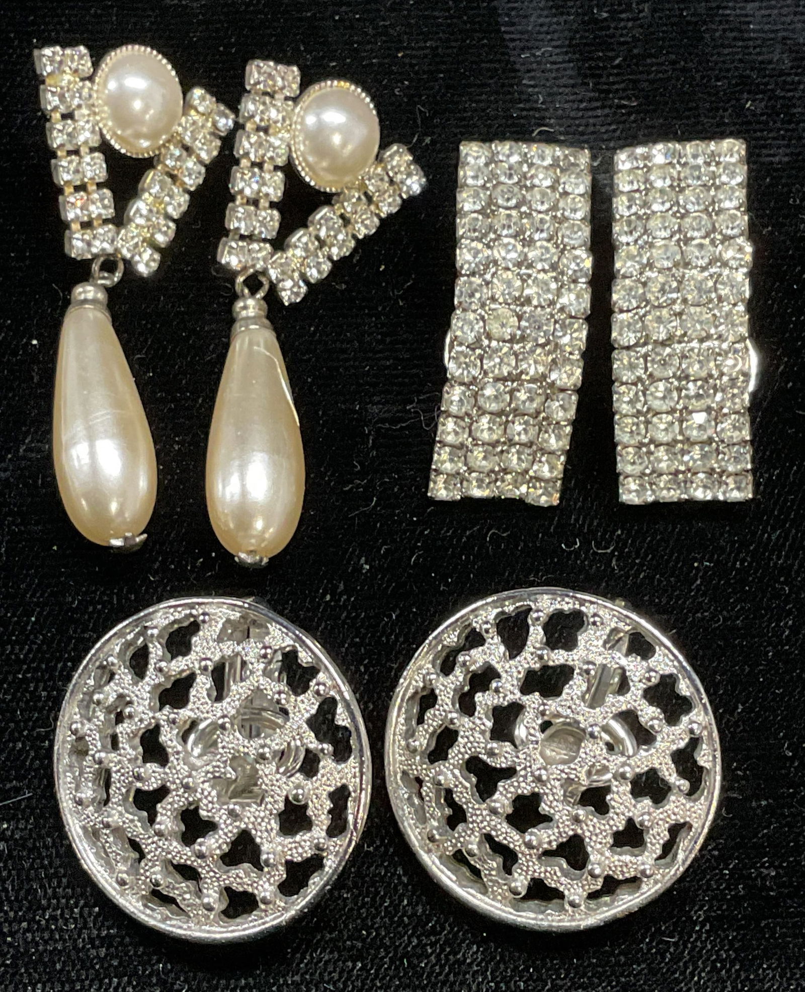 Lot 3 Trifari Silver Tone Earrings + More: Lot of 3 pairs of earrings. Trifari silver tone pierced round earrings, silver tone crystal and faux pearl drop earrings, and silver tone crystal earrings. Largest approx 1.75 inches long. All pieces