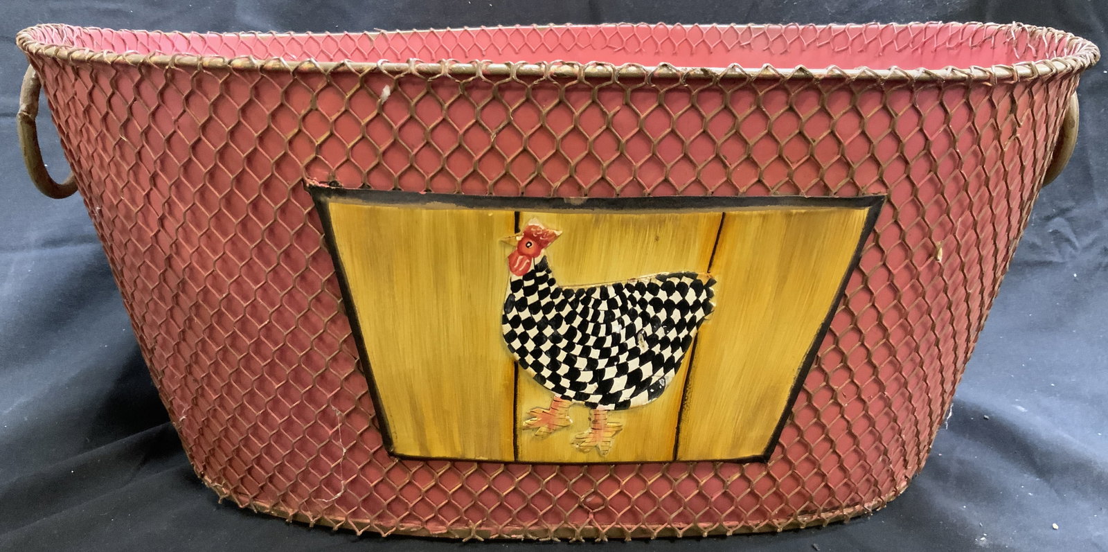 Toleware Netted Planter Vessel W Handles: Vessel is pink toned. Piece is toleware. Exterior has netted wiring. Piece has oval form. Sides of piece have circular loop handles. Sides have images of chickens. Each piece measures approximately 17