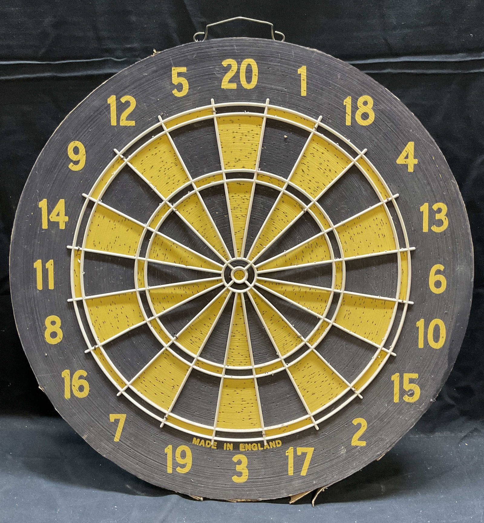 Vintage Black & Yellow Dart Board, England: Vintage black and yellow dart board. Cardboard. Made in England. Measures approx 17.5 inches wide. Wear including chips, wear consistent with use. Dart board, dartboard, vintage dart board, bar decor,