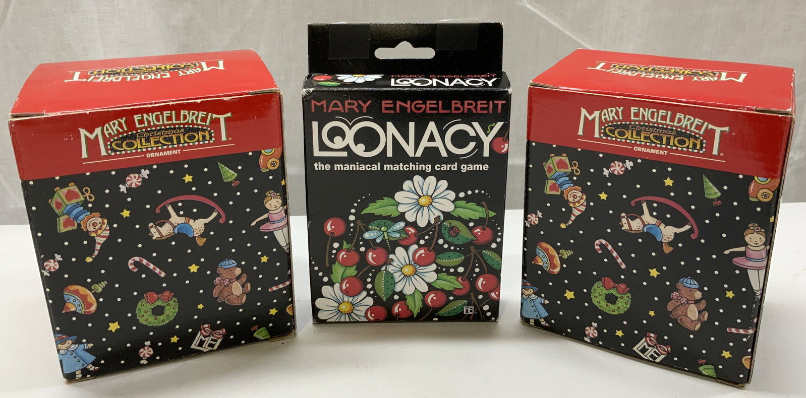 Mary Engelbreit Christmas Ornaments & Cards NIB: Mary Engelbreit Christmas Ornaments & Cards NIB 2 NIB Christmas ornaments shaped like a teacup & saucer. Has candy canes, red flowers & floral pattern. 1 NIB Loonacy the maniacal matching card game. A