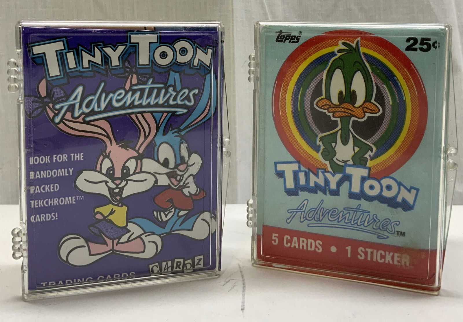 Group Lot 1991 TOPPS&1994 CARDZ TINY TOON CARDS: Group Lot 1991 TOPPS&1994 CARDZ TINY TOON CARDS A group lot of 1991 TOPPS TINY TOON ADVENTURES trading cards & 1994 CARDZ TINY TOON ADVENTURES trading cards. Plastic container is holding cards inside.