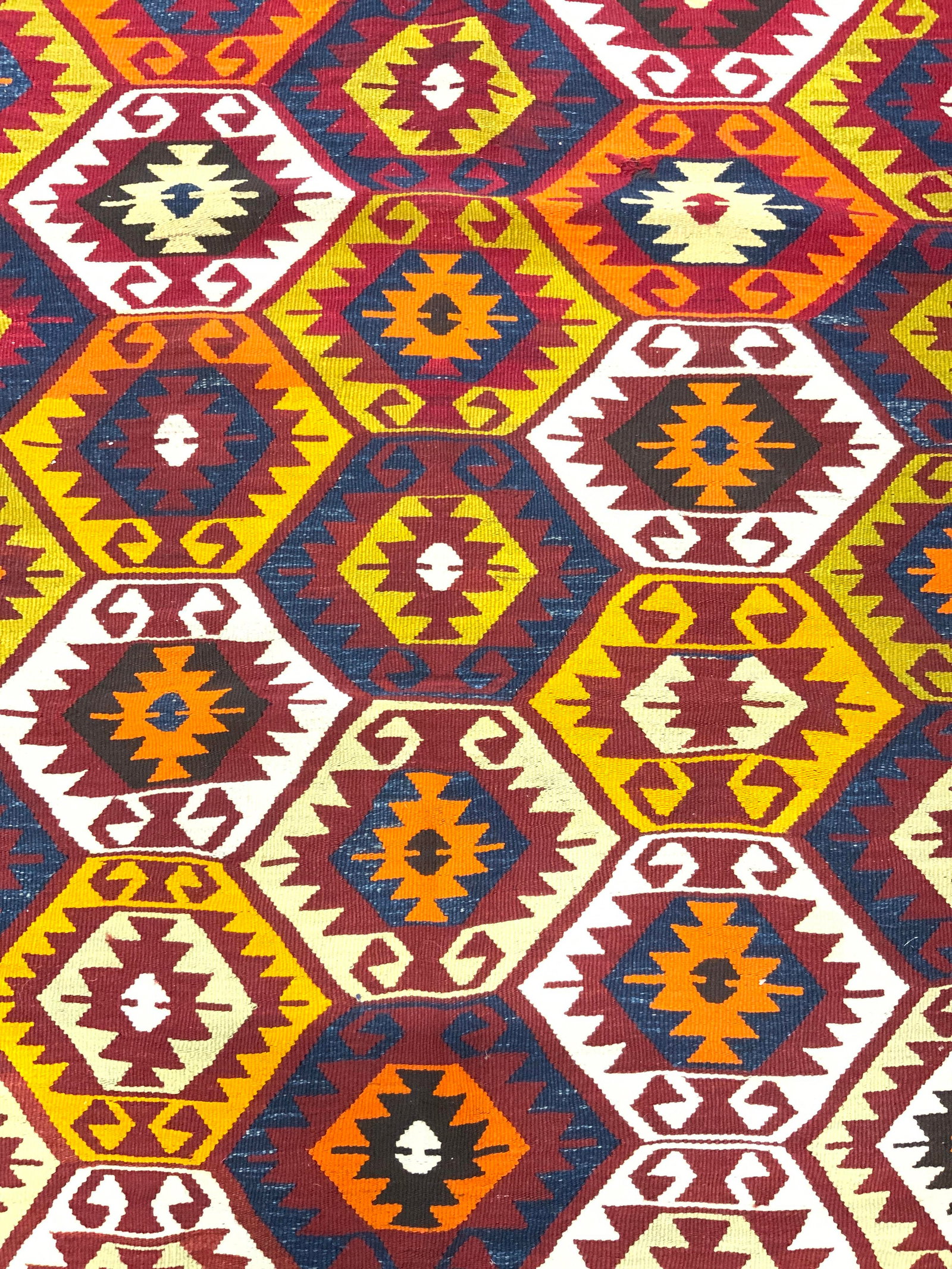 Handmade Kilim Fringed Wool Area Rug: Rug is handmade and wool. Piece has multi toned geometric detail. One edge of rug has brown toned knotted fringes. Rug measures approximately 66 inches long 39 inches wide. Rug, handmade rug, Kilim ru