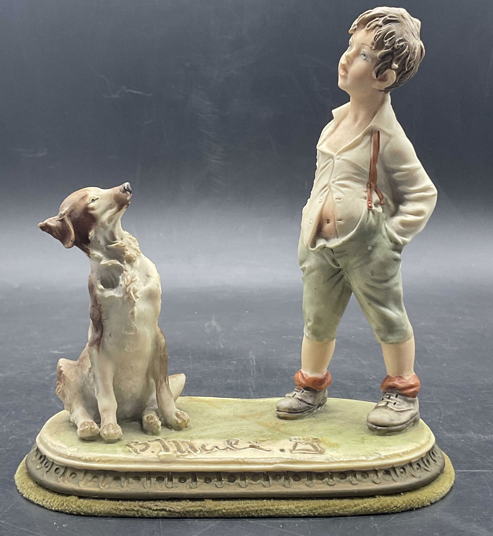 Vintage B. Merli Capodimonte Boy W/ Dog Fig: Vintage B. Merli Capodimonte Resin Boy with Dog Sculpture. Measures approx. 6H x 5.75W in. Felt to the underside. Chipping, surface wear, and residue present. home decor, home accents, homewares, hous