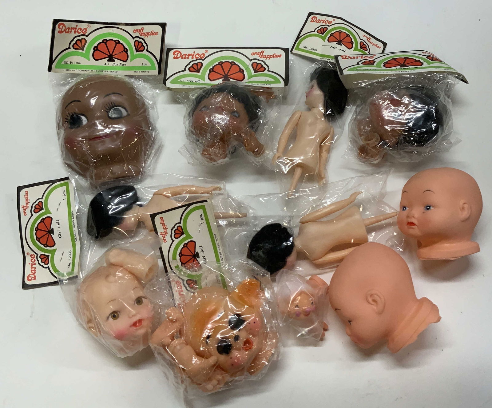 Vntg Hong Kong Darice Craft Supply Dolls&Heads NIP: Vntg. Hong Kong Darice Craft Supply Dolls & Heads Variety of doll heads & girl dolls from Hong Kong. Majority of dolls are new in plastic. Each one has distinctive details and colors. Signed & marked