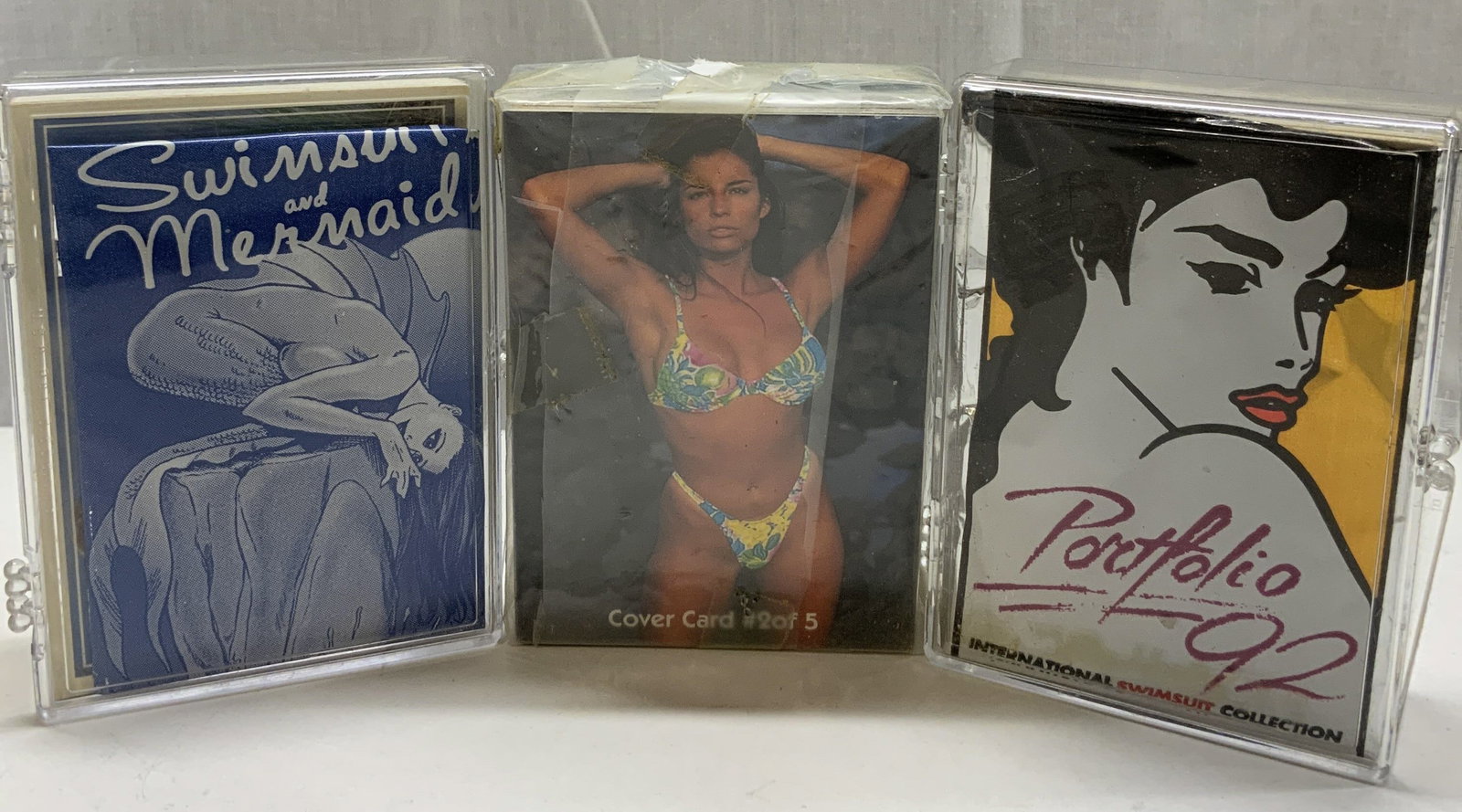 Lot 1996 Swimsuit&Mermaid, Portfolio92 Trading Crd: Group Lot 1996 Swimsuit&Mermaid, Portfolio92 Trading Cards A group lot of 1996 Swimsuit & mermaid trading cards, portfolio 92 trading cards & a deck of cards that have not been examined or opened. Pla