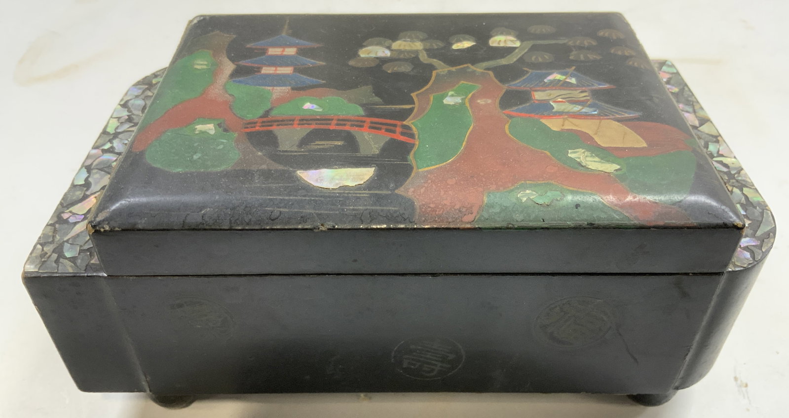 Vtg Asian jewelry Box W Mother Of Pearl Inlay: Jewelry box is vintage. Piece has hinged lid. Jewelry box plays music, has wind on underside. Interior has compartment for music mechanism and 1 storage compartment. Piece is black with mother of Pear