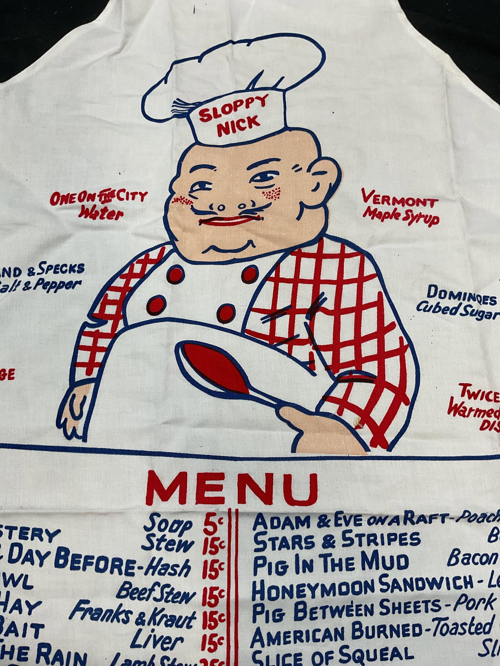 Sloppy Nick Chef Menu Print Cotton Apron: Cotton apron. Graphic print. Sloppy Nick chef and menu design. Measures approx 24 x 34 inches. Some blemishes observed. Apron, cotton apron, chef apron, menu apron, wearables, kitchen accessories, hom