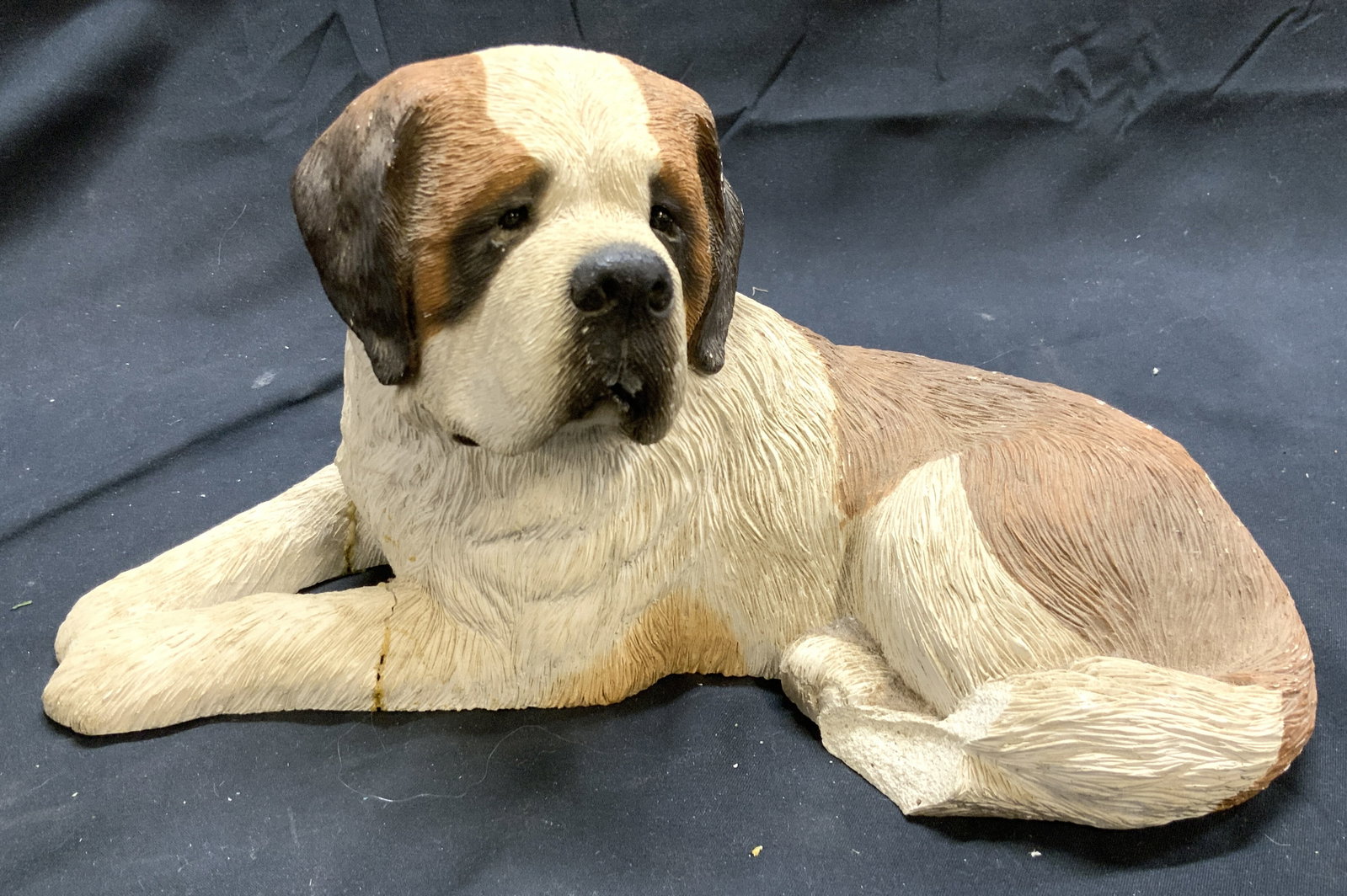 SANDICAST ST BERNARD Vintage dog Figure: Tag on Underside reads SANDICAST ST BERNARD. Dog figure is vintage. Crafted from poly resin. Depicts a laying St Bernard dog looking to the side. Tag also reads handcast and hand painted. Piece measur