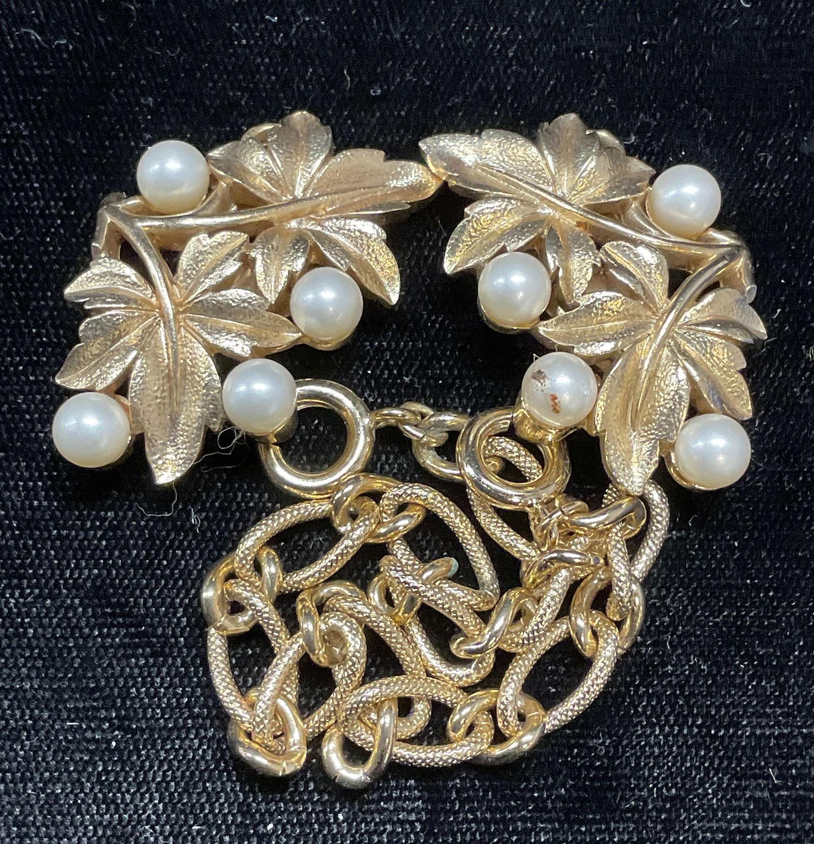 Trifari Gold Tn Faux Pearl Sweater Clip/Earrings: Vintage Trifari gold tone double faux pearl and leaf motif sweater clips/earrings with removable chain. Signed on underside. Clips measure approx 1.5 inches long. Some wear including scratching observ
