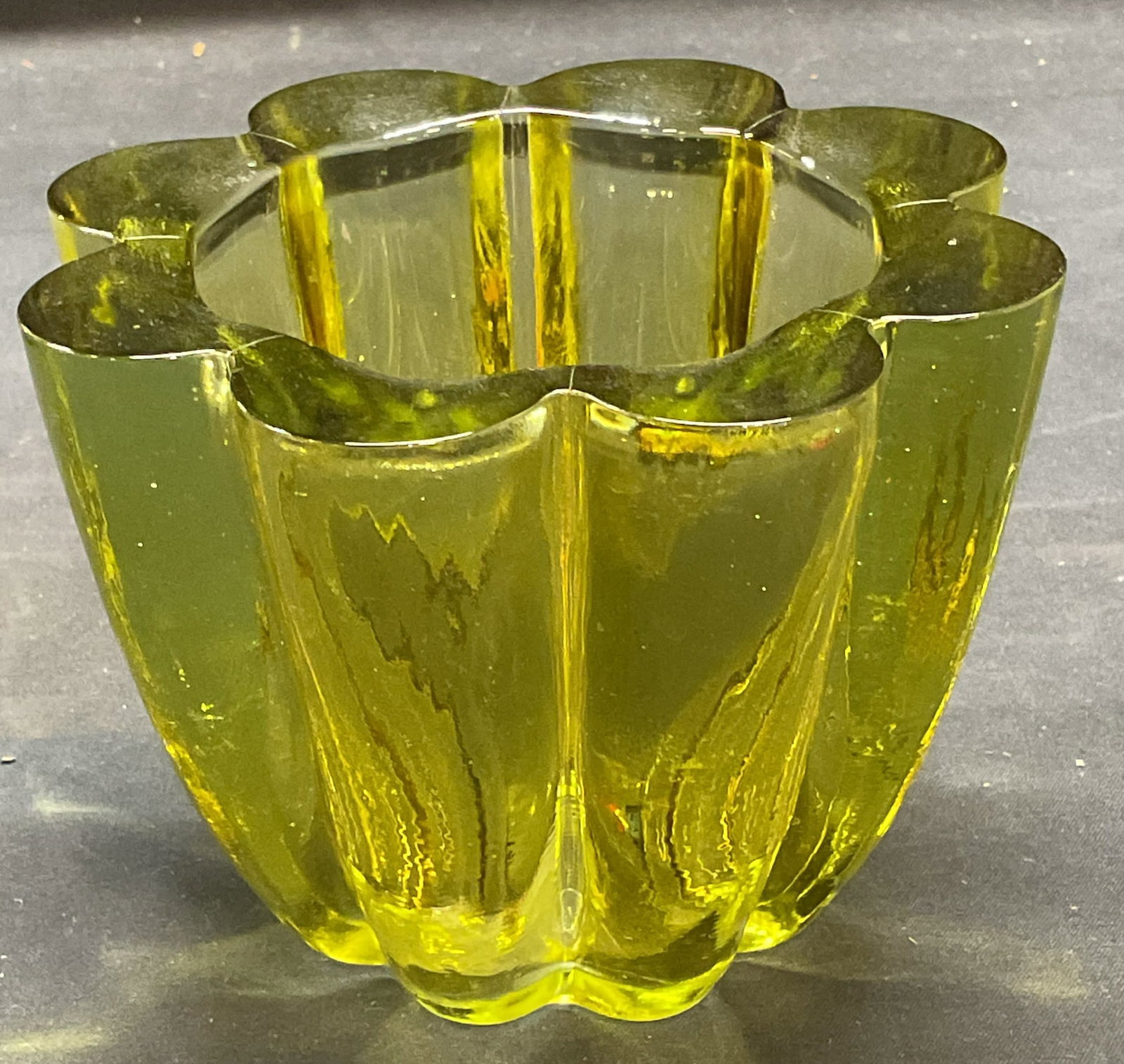Green Scalloped Art Glass Candle Holder: Green art glass votive candle holder. Ribbed design with scalloped rim. Measures approx 4.75 x 3.75 inches. Some wear including scratching observed. Art glass, art glass candle holder, votive candle h