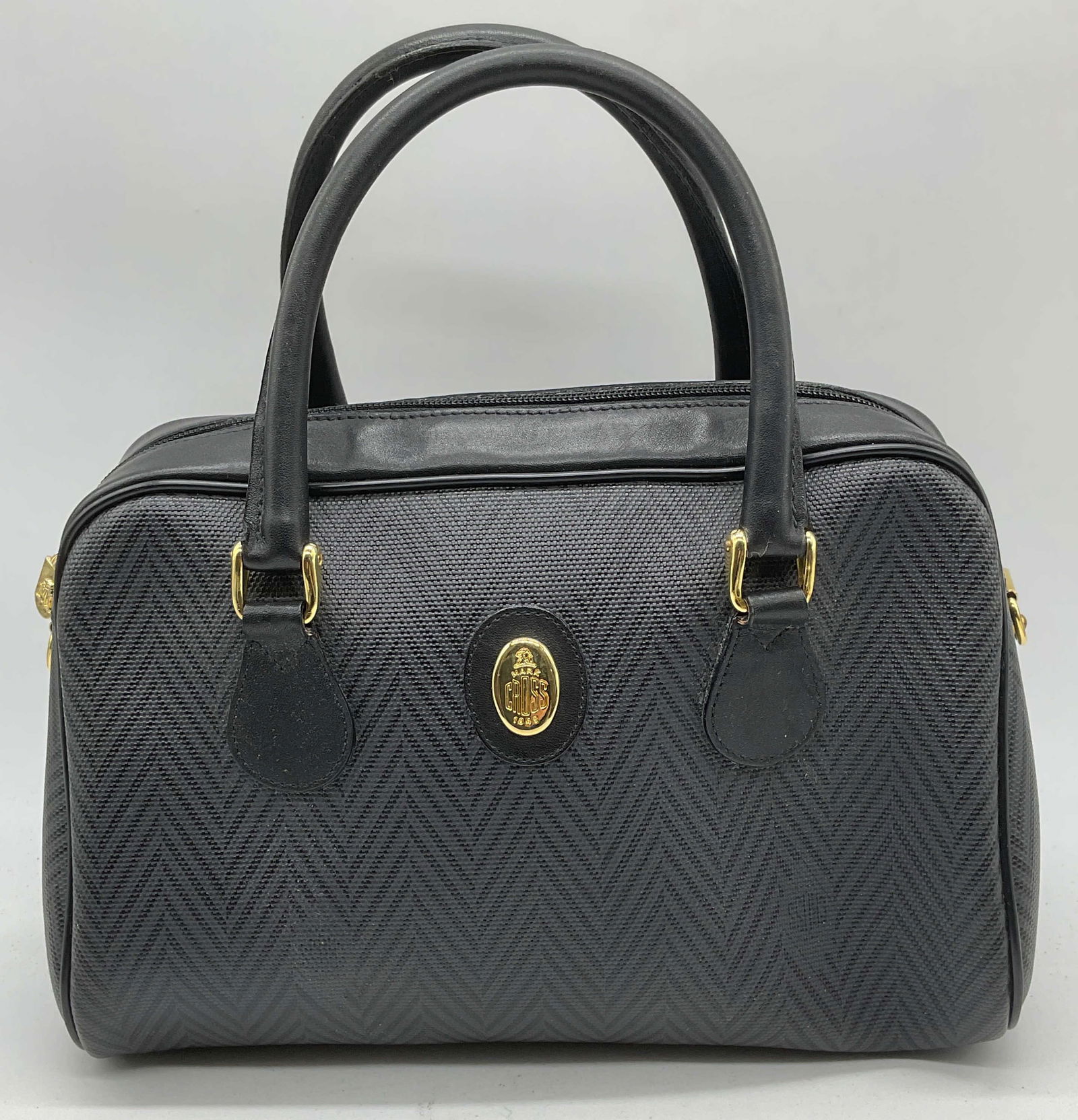 Vintage Mark Cross Black Chevron Handbag: Vintage Mark Cross black and grey chevron pattern handbag. Canvas with leather handles and trim. Gold tone hardware. Signed on exterior and interior. Zippered interior pockets. Measures approx 10 x 5.